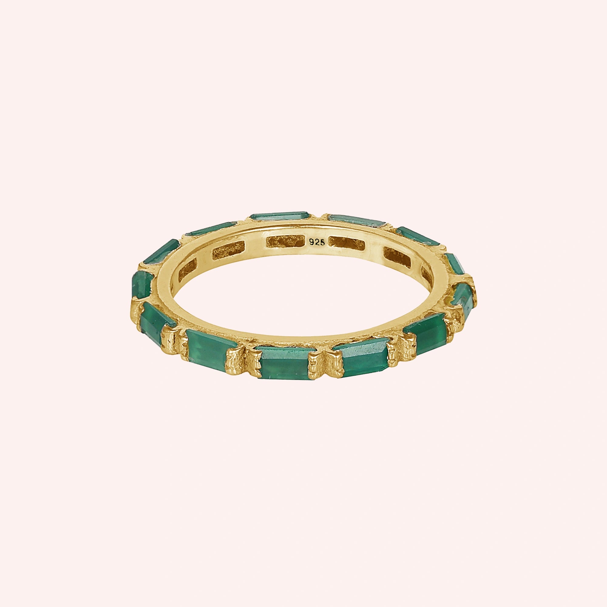 Gold-plated sterling silver green onyx ring with baguette stones bar set elevated angle view against a light pink background