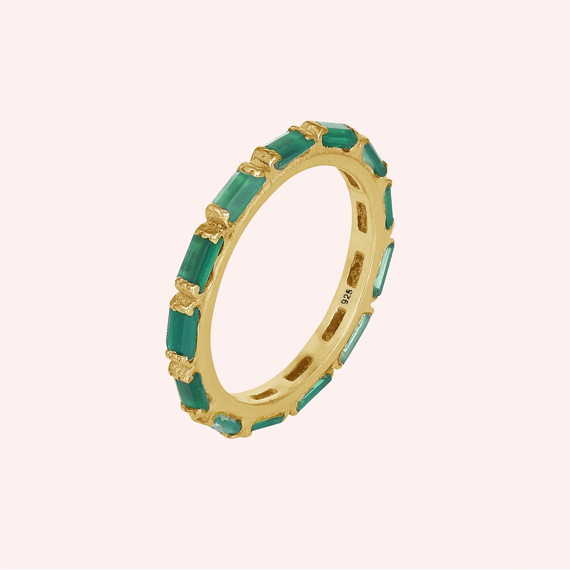 Gold-plated sterling silver green onyx ring with baguette stones bar set elevated angle view against a light pink background