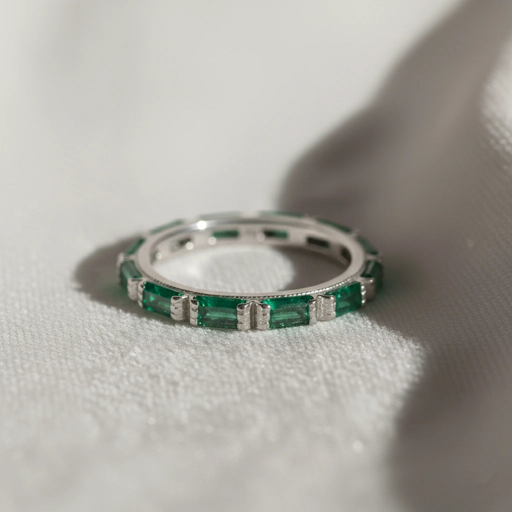 Sterling silver green onyx ring with baguette stones bar set low angle close up view on draped white cloth background