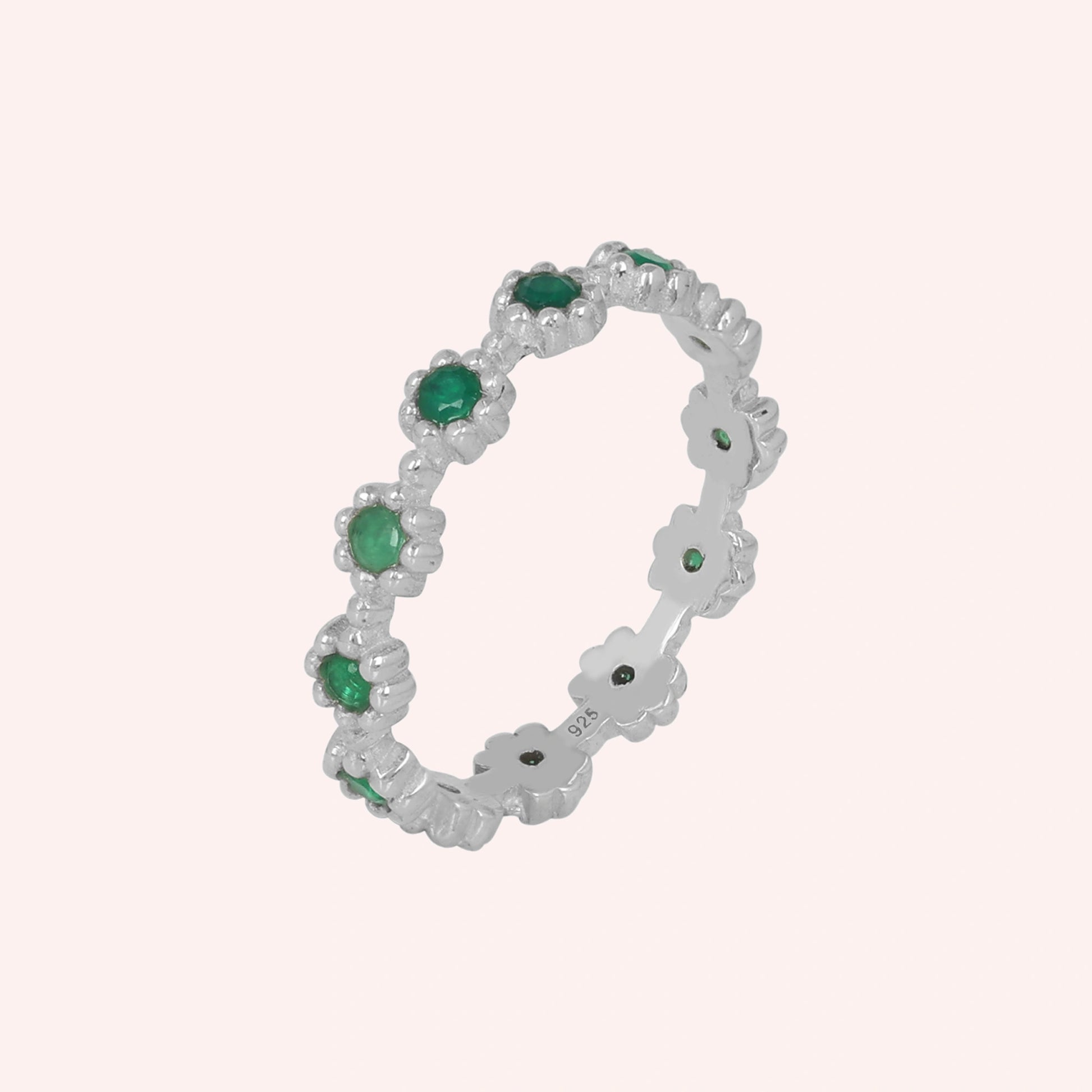 Angled sterling silver onyx eternity ring on a soft pink background featuring exquisite green onyx gemstones capturing radiant elegance.