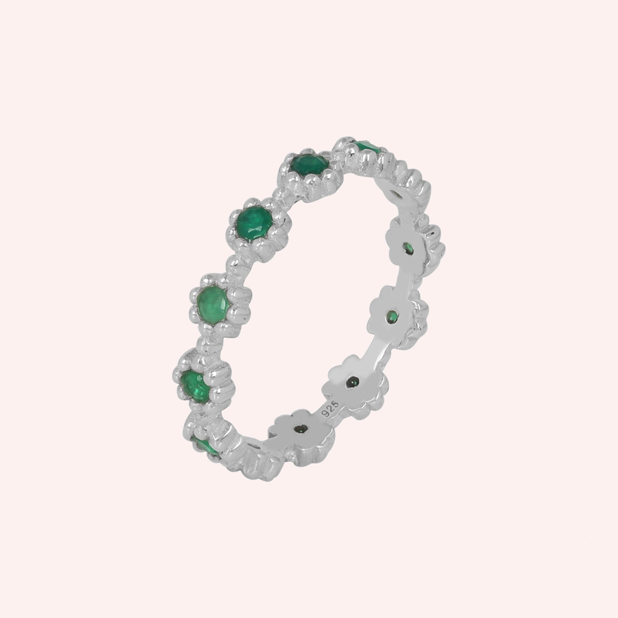 Angled sterling silver onyx eternity ring on a soft pink background featuring exquisite green onyx gemstones capturing radiant elegance.