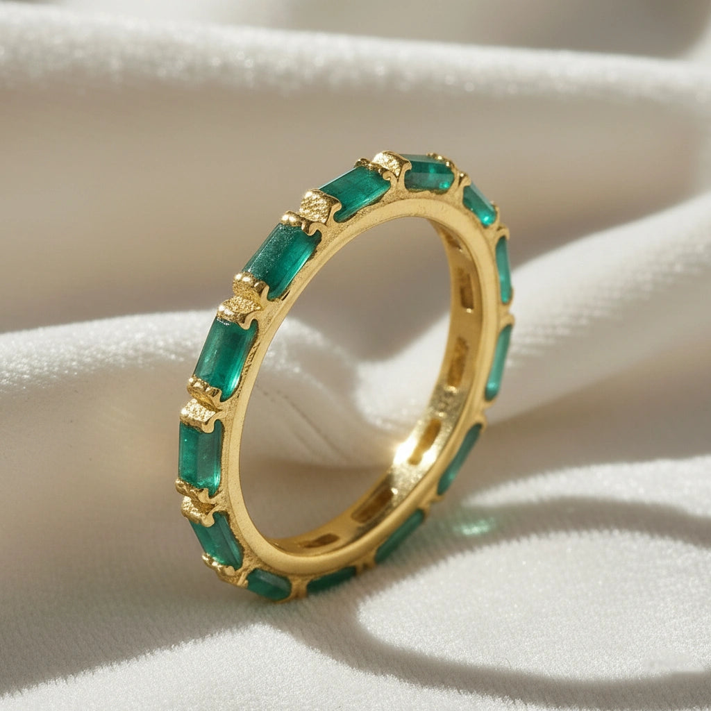 Gold-plated sterling silver green onyx ring with baguette stones bar set elevated view on a white velvet fabric background