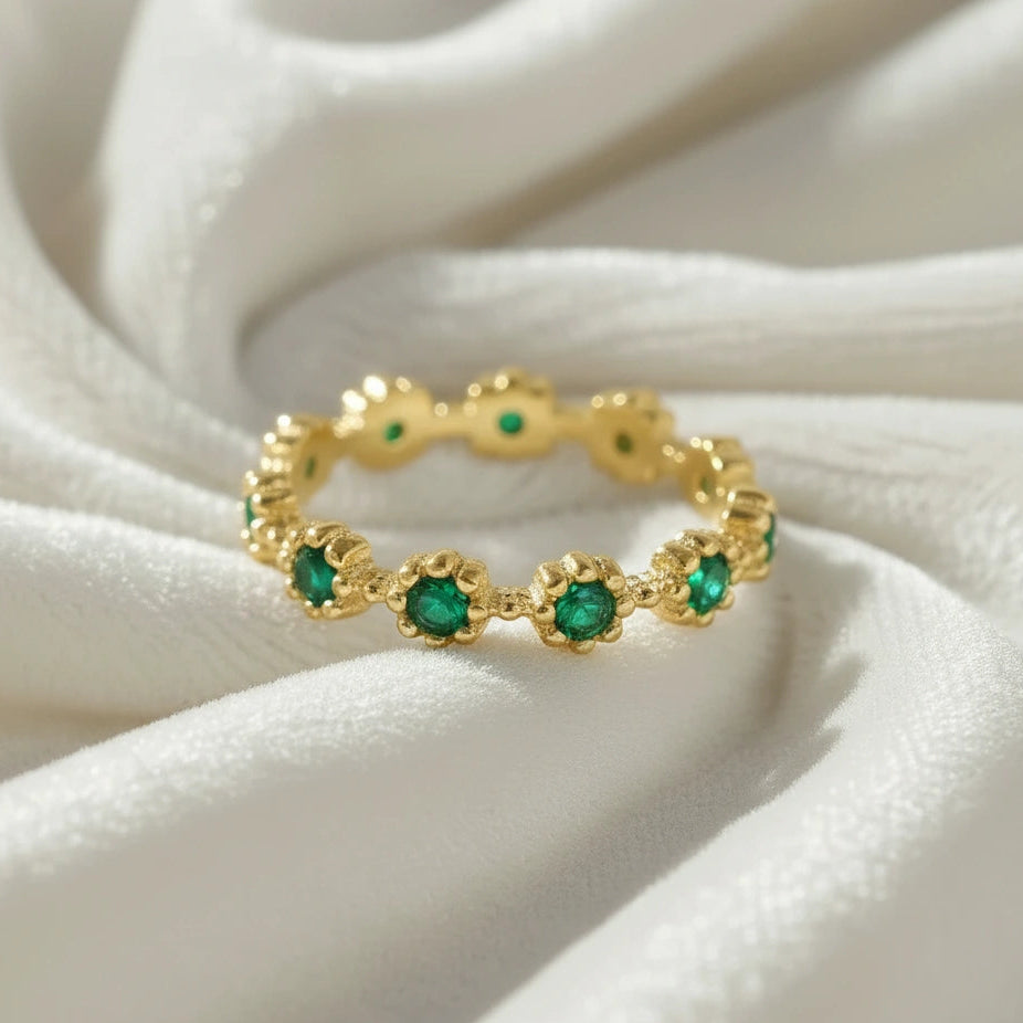 Close up angled sterling silver onyx eternity ring on a soft white fabric showcase with green onyx gemstones capturing brilliant detail.