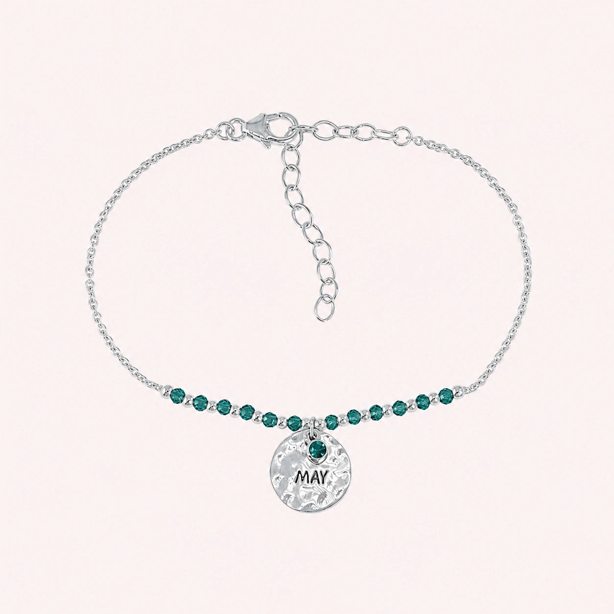 Birthstone_bracelet_in_sterling_silver_with_May_charm_and_green_onyx_beads_on_fine_chain_on_solid_pink_background