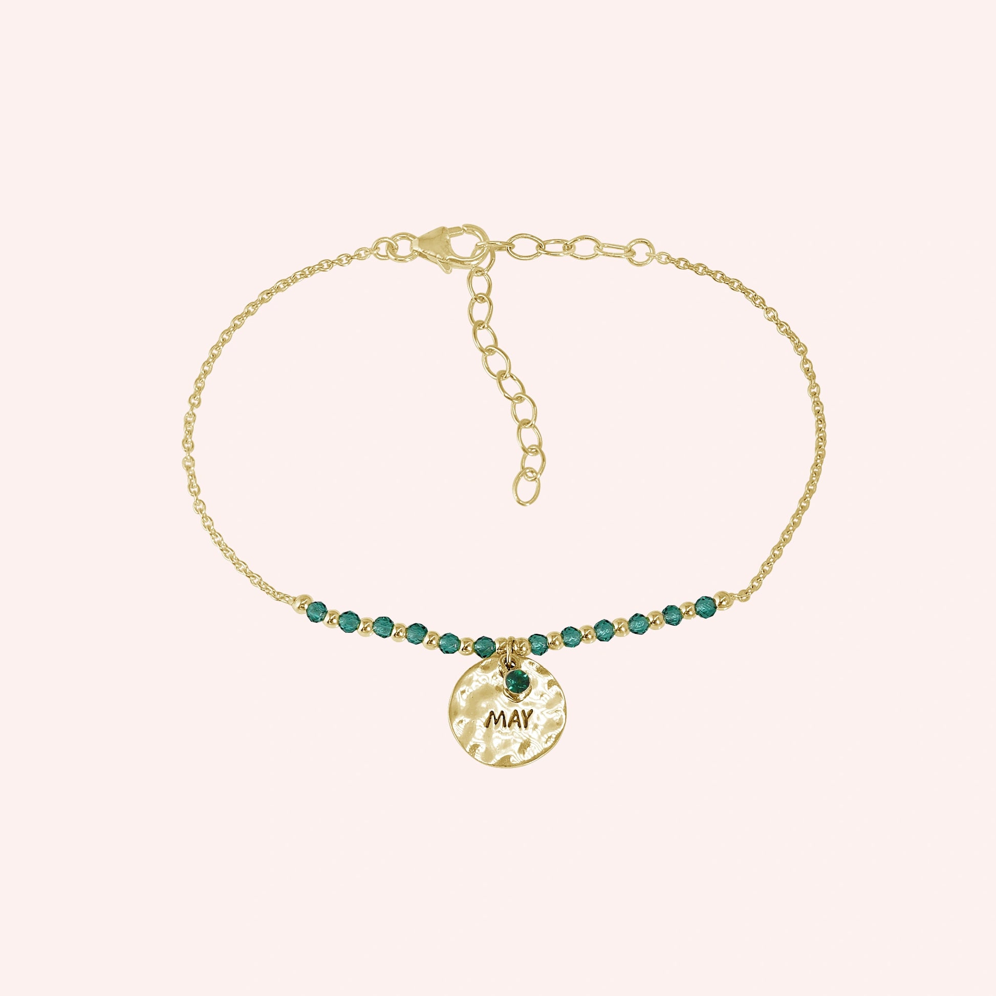 Birthstone_bracelet_in_gold_plated_silver_with_May_charm_and_green_onyx_beads_on_fine_chain_on_solid_pink_background
