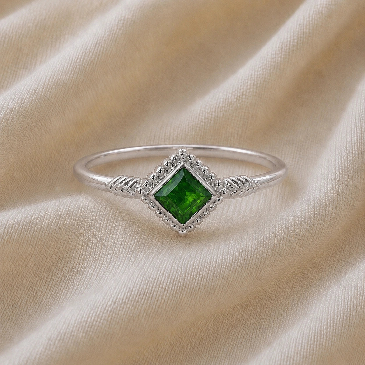 Princess_cut_ring_sterling_silver_with_square_green_tourmaline_and_detailed_band_front_angle_view_on_soft_fabric_background
