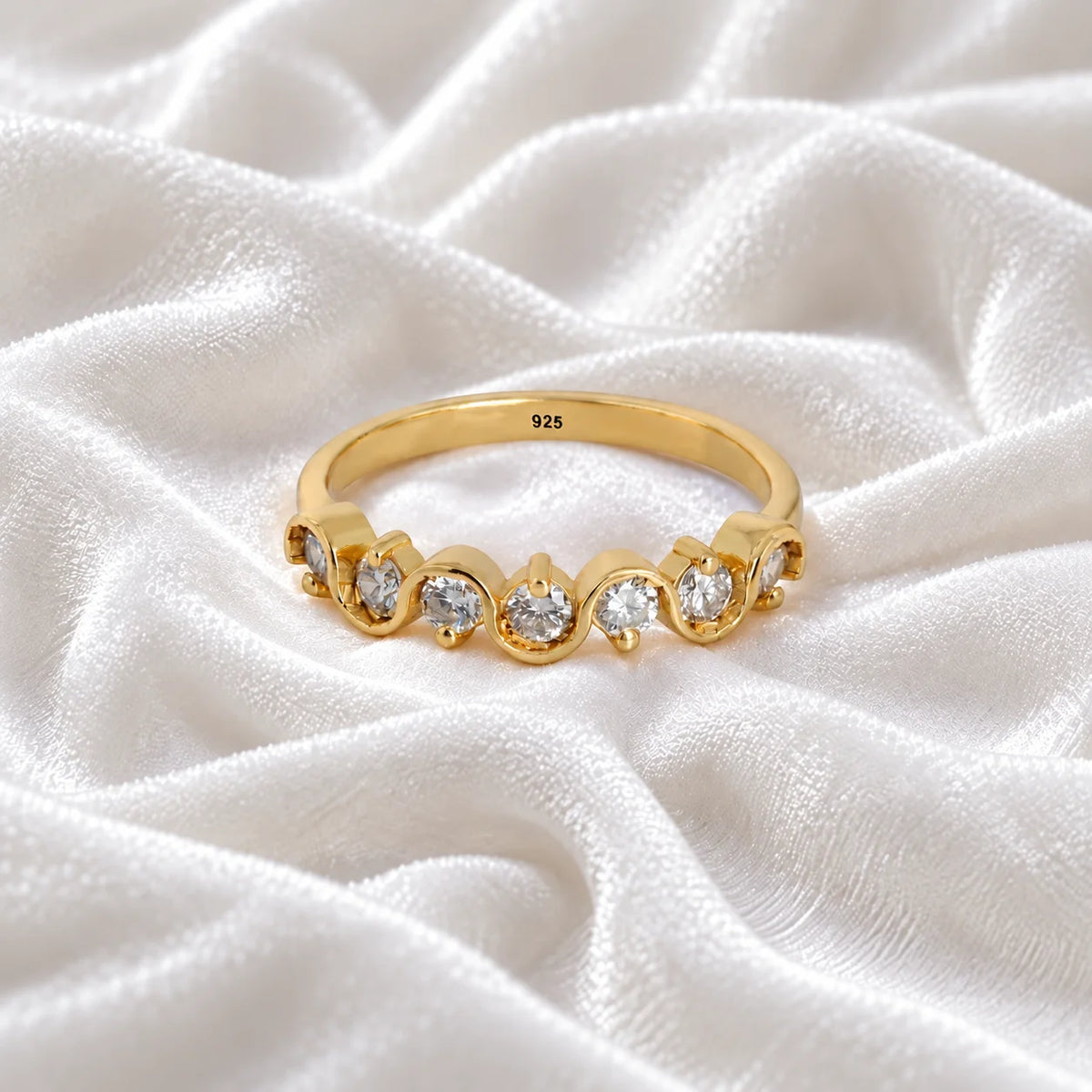 Diamond_ring_in_gold_plated_silver_with_half_eternity_design_at_front_angle_view_on_soft_fabric_background