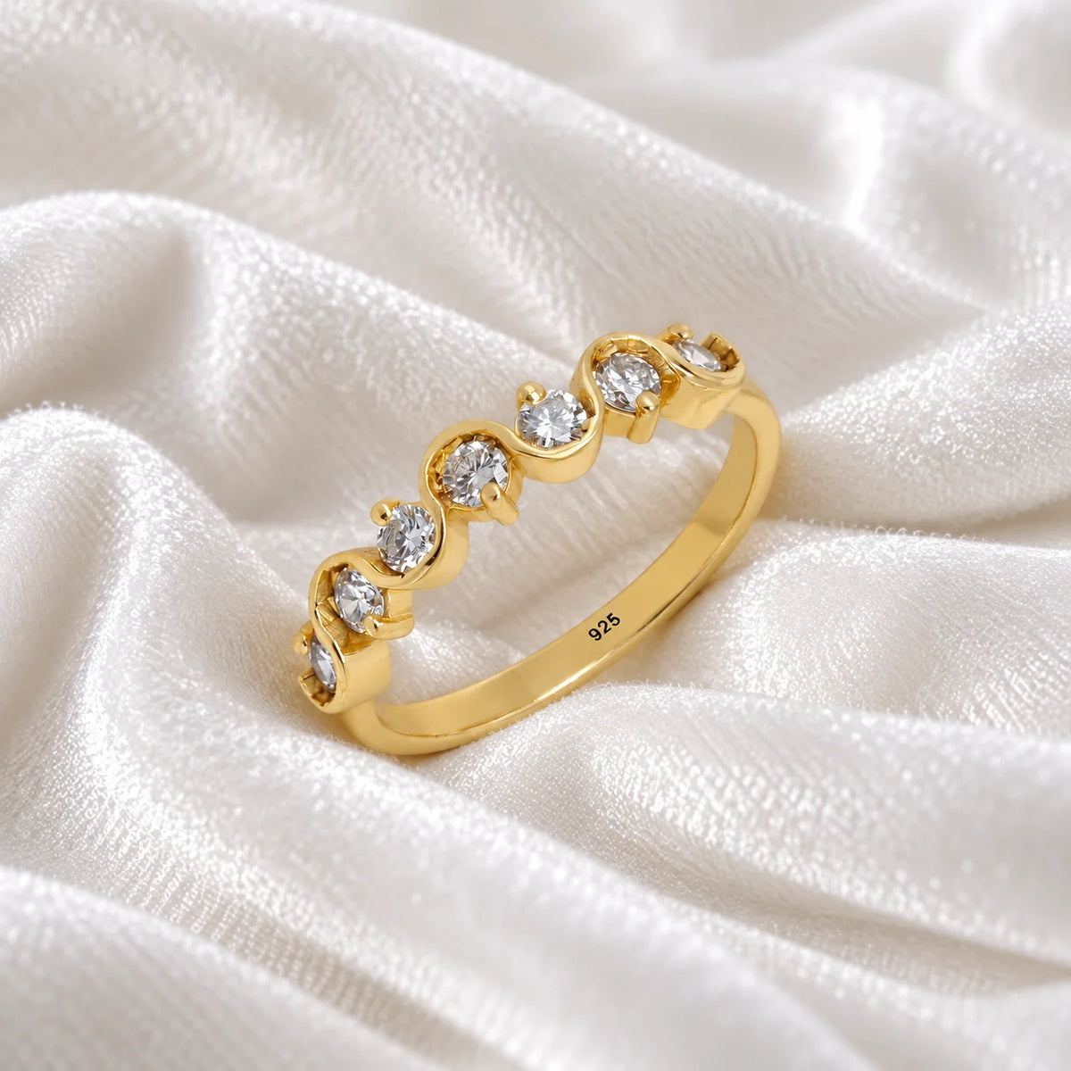 Diamond_ring_in_gold_plated_silver_with_half_eternity_design_at_side_angle_view_on_soft_fabric_background