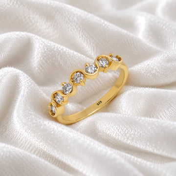 Diamond_ring_in_gold_plated_silver_with_half_eternity_design_at_side_angle_view_on_soft_fabric_background