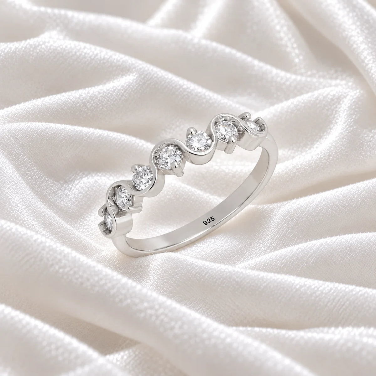 Diamond_ring_in_sterling_silver_with_half_eternity_design_at_side_angle_view_on_soft_fabric_background