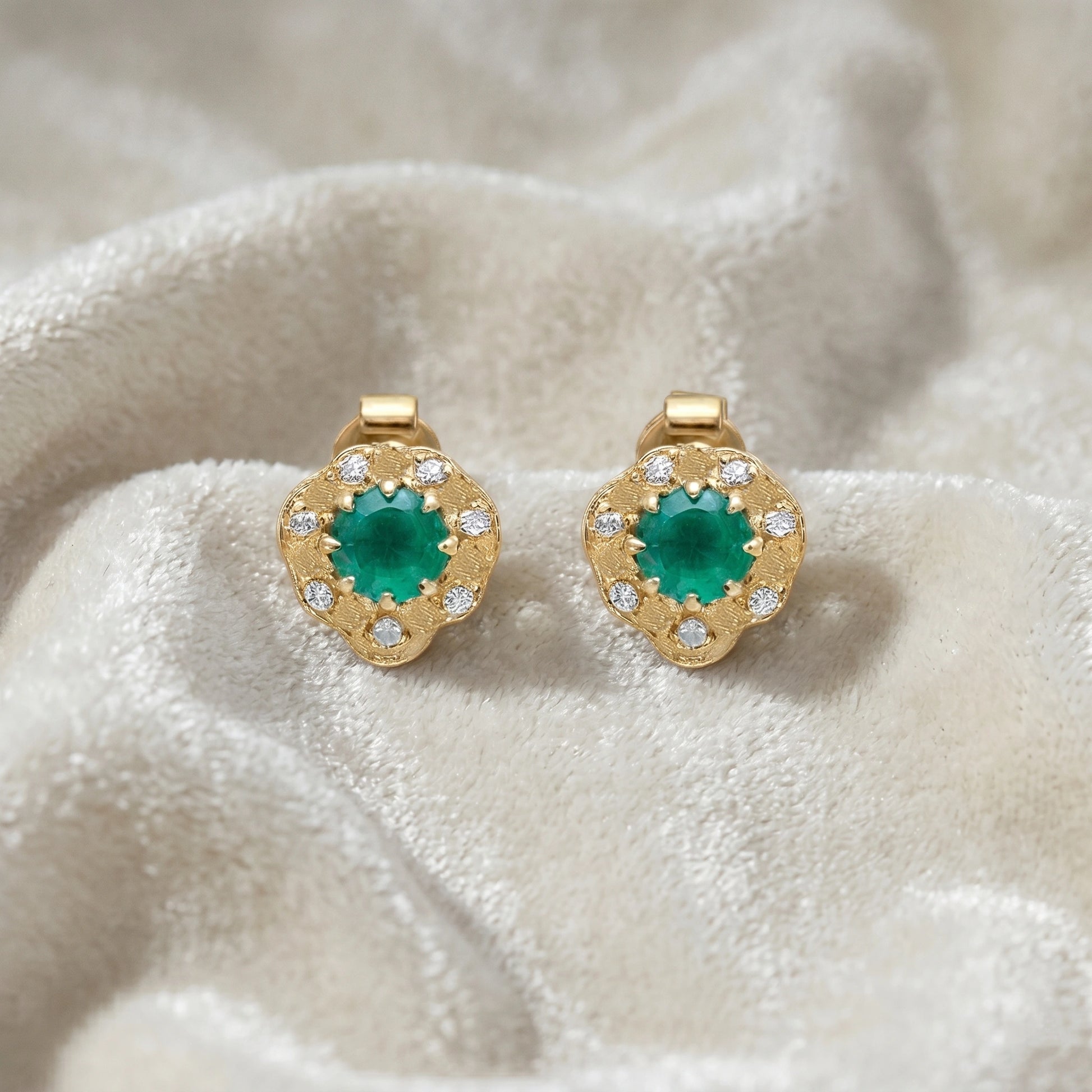 Halo_stud_earrings_in_gold_plated_silver_with_green_onyx_and_white_topaz_stones_at_front_angle_on_soft_fabric_background