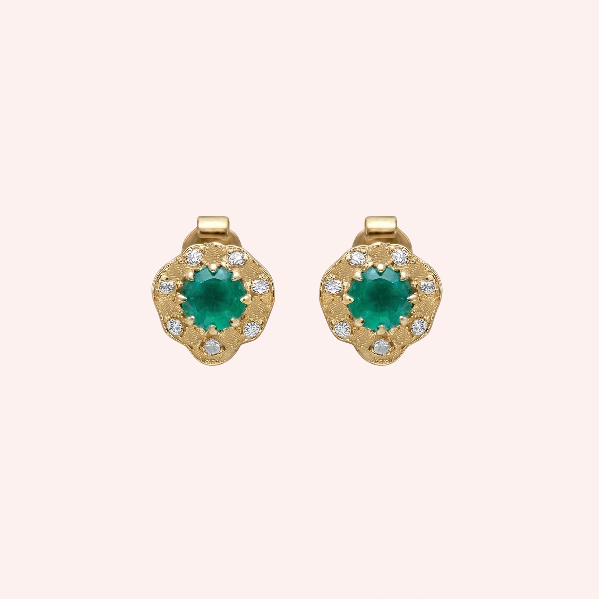 Halo_stud_earrings_in_gold_plated_silver_with_green_onyx_and_white_topaz_stones_at_front_angle_on_solid_pink_background