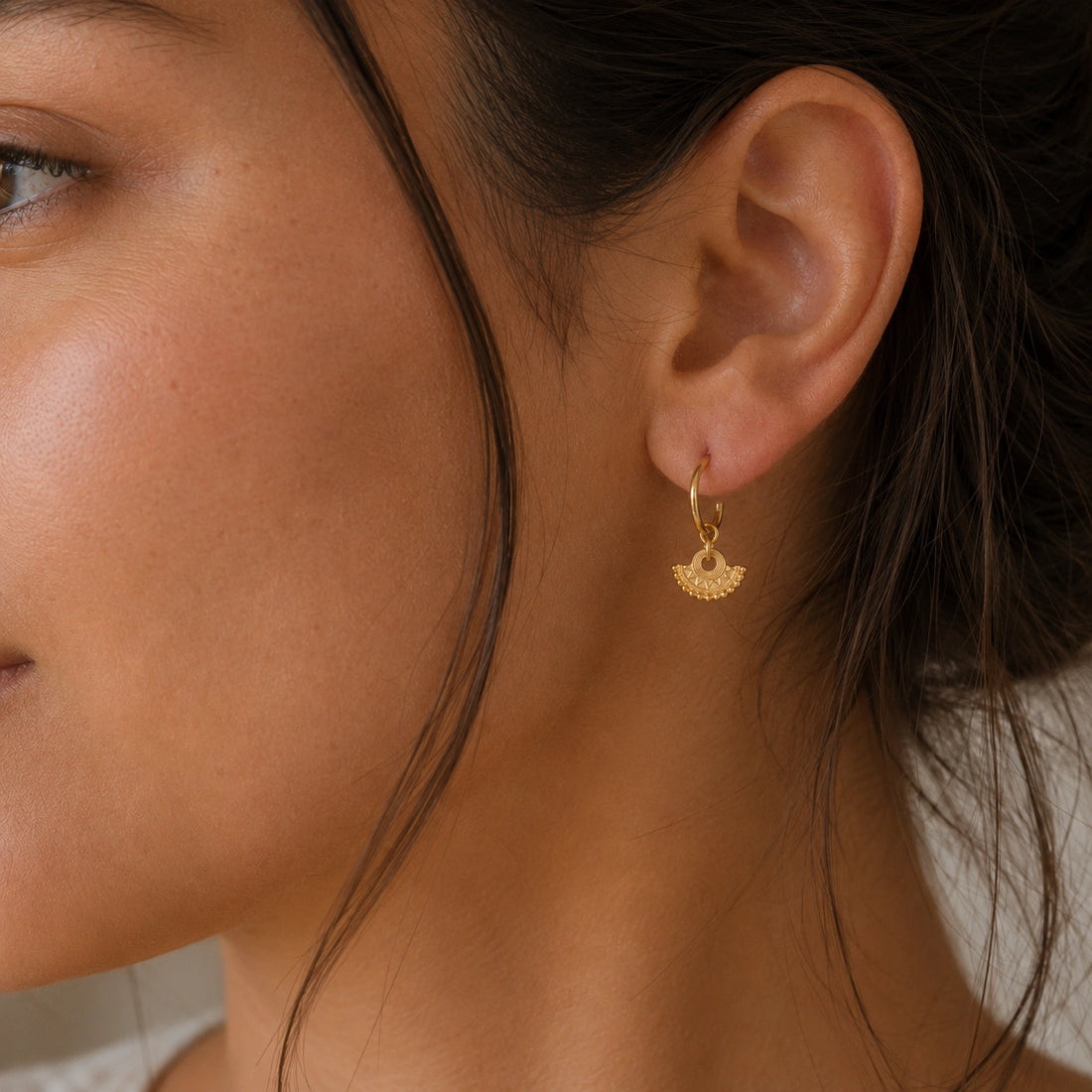Handmade_earrings_in_gold_plated_silver_with_handcrafted_design_hoops_at_front_angle_on_soft_fabric_background