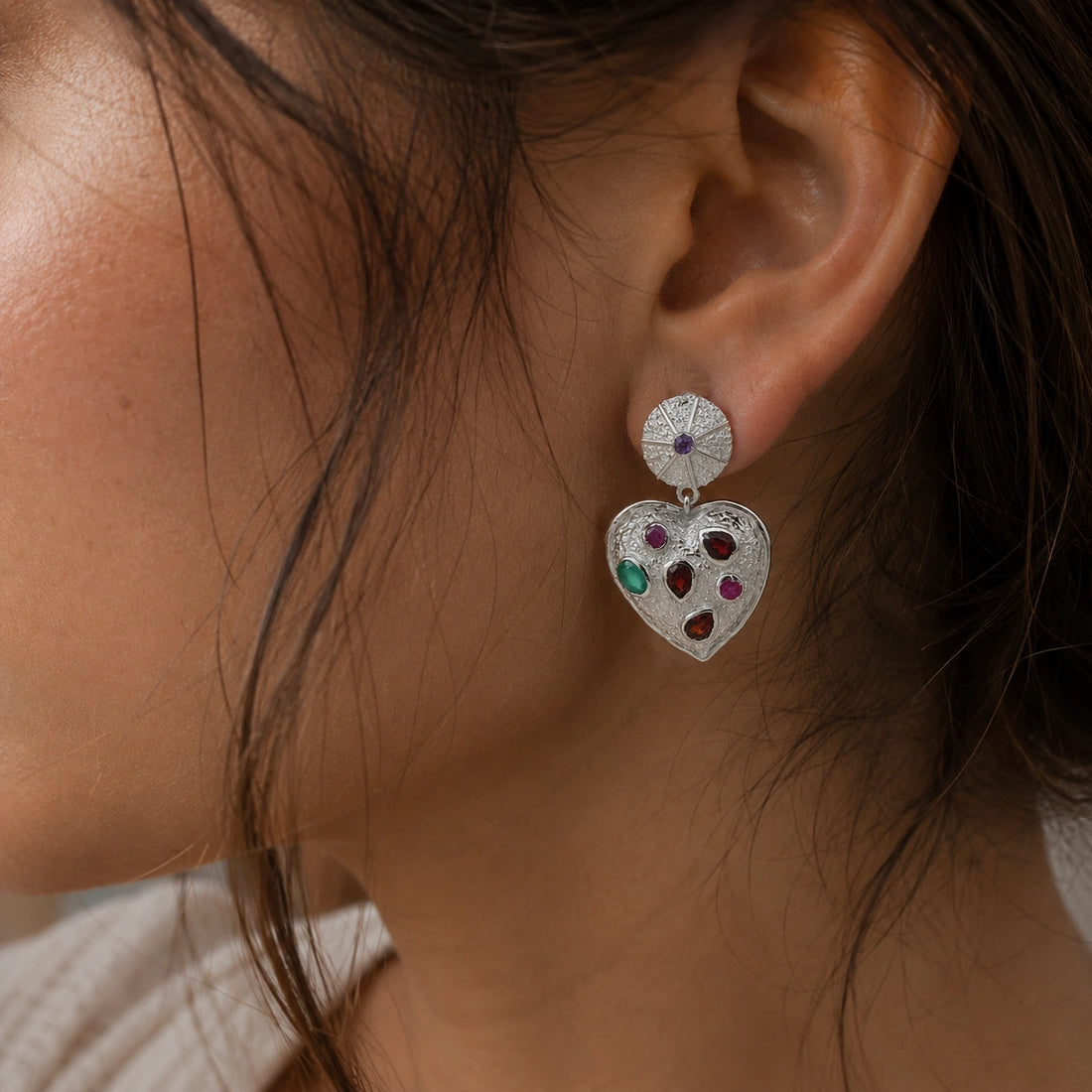 Heart_earrings_in_gold_plated_silver_with_garnet_ruby_and_green_onyx_stones_slightly_angled_on_soft_fabric_background