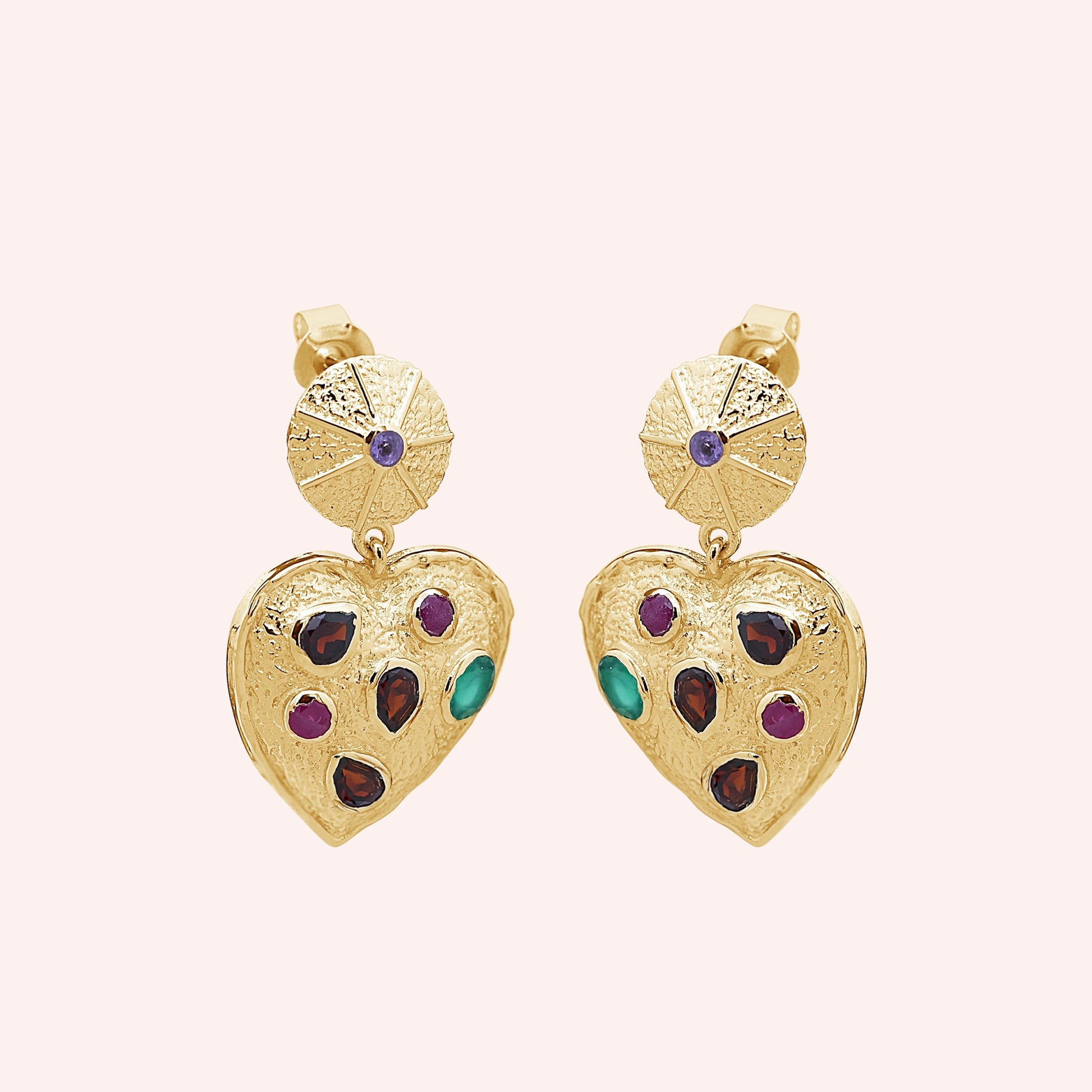 Heart_earrings_in_gold_plated_silver_with_garnet_ruby_and_green_onyx_stones_slightly_angled_on_solid_pink_background