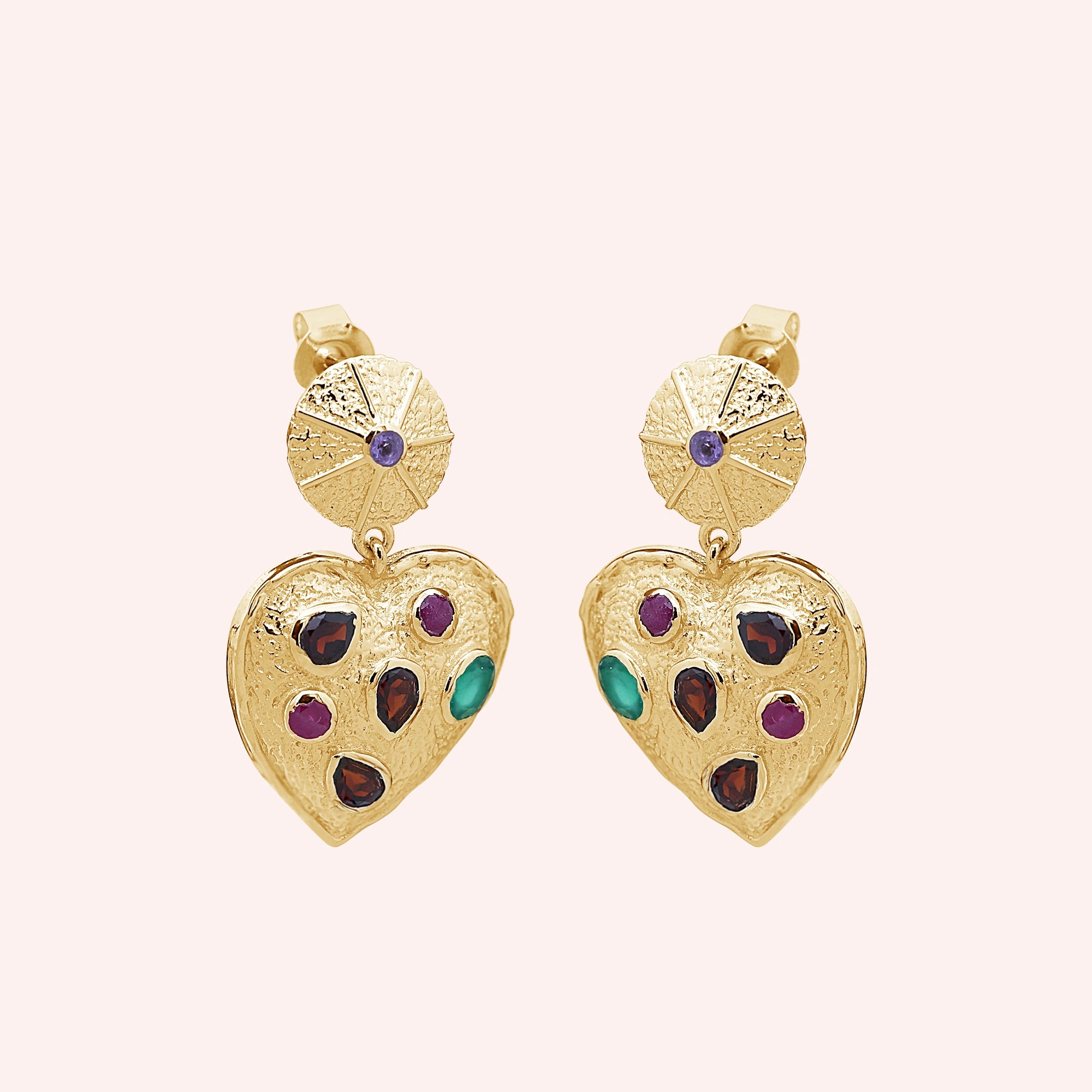 Heart_earrings_in_gold_plated_silver_with_garnet_ruby_and_green_onyx_stones_slightly_angled_on_solid_pink_background