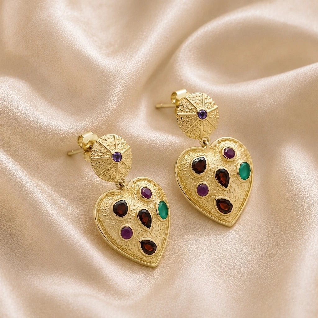 Heart_earrings_in_gold_plated_silver_with_garnet_ruby_and_green_onyx_stones_slightly_angled_on_soft_fabric_background
