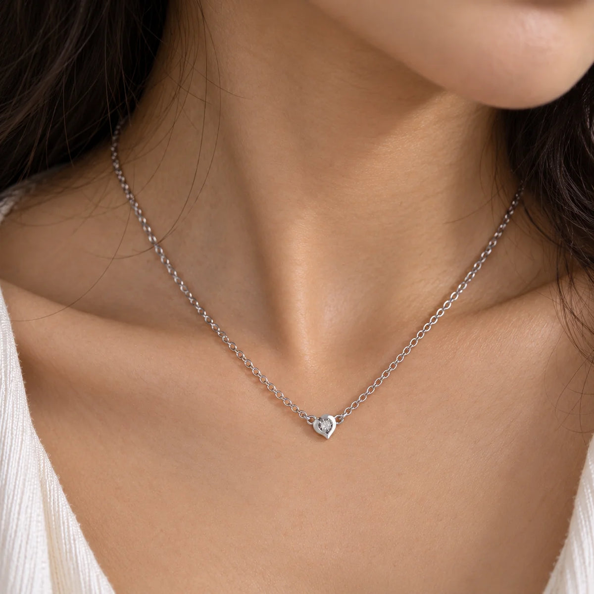 Heart_necklace_in_sterling_silver_with_a_small_round_lab_grown_diamond_worn_by_a_model