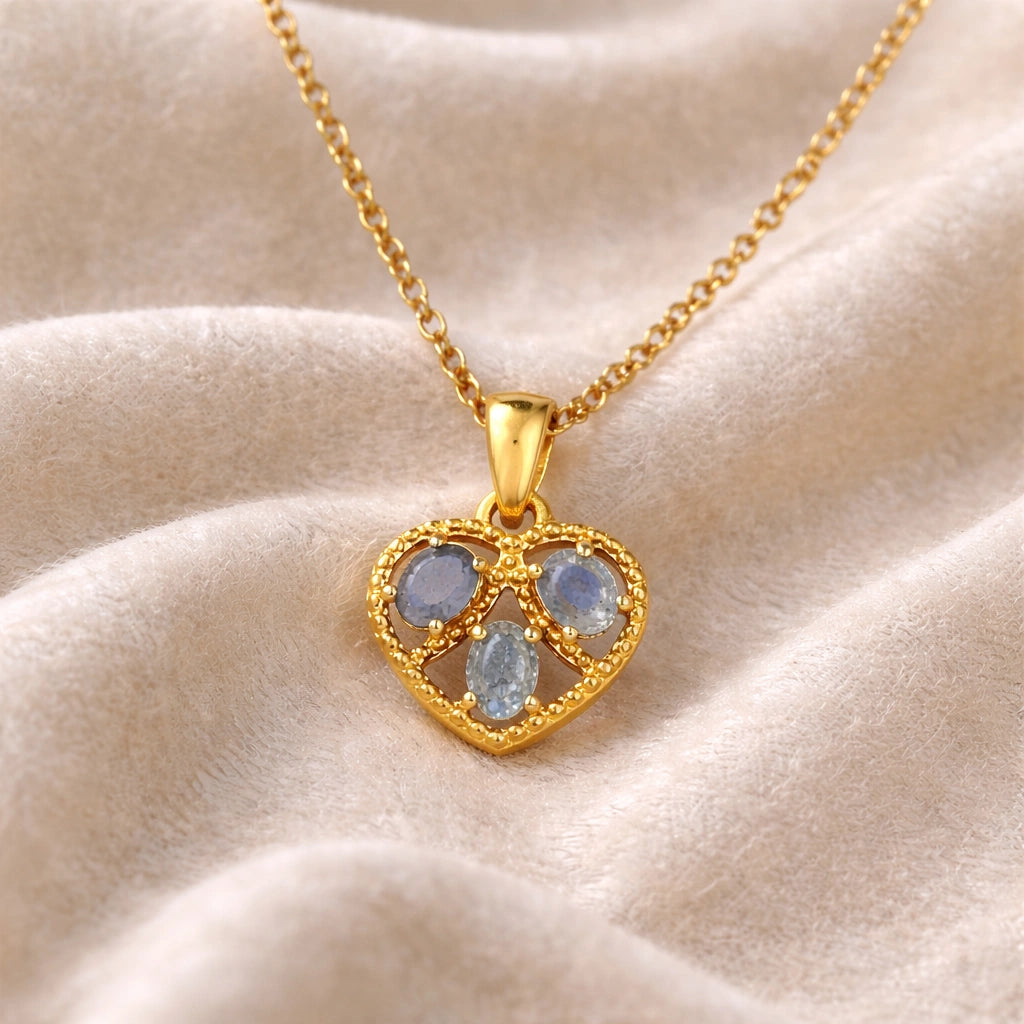 Heart_pendant_necklace_in_front_angled_view_with_gold_plated_silver_heart_and_labradorite_stones_on_soft_fabric_background