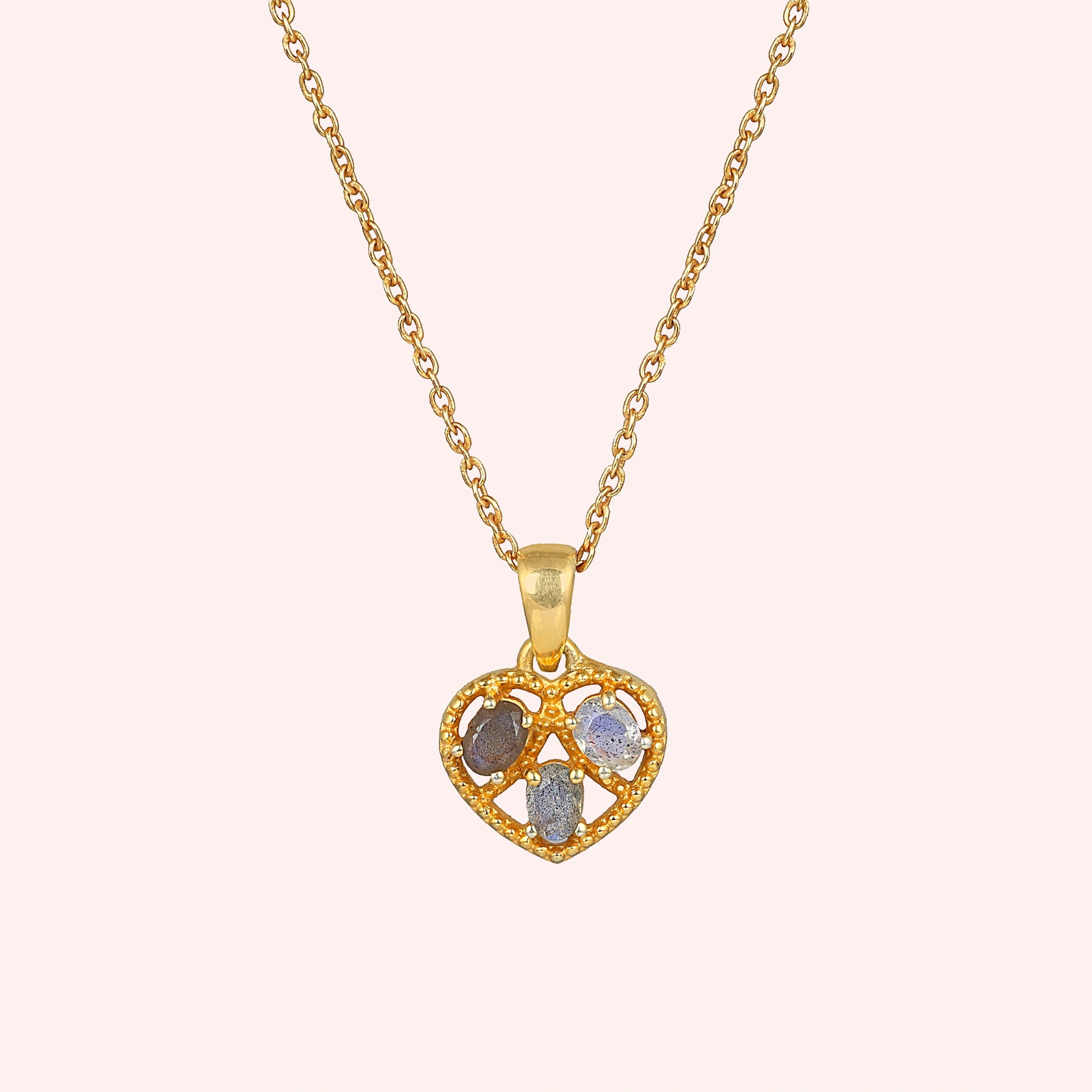 Heart_pendant_necklace_in_front_angled_view_with_gold_plated_silver_heart_and_labradorite_stones_on_solid_pink_background