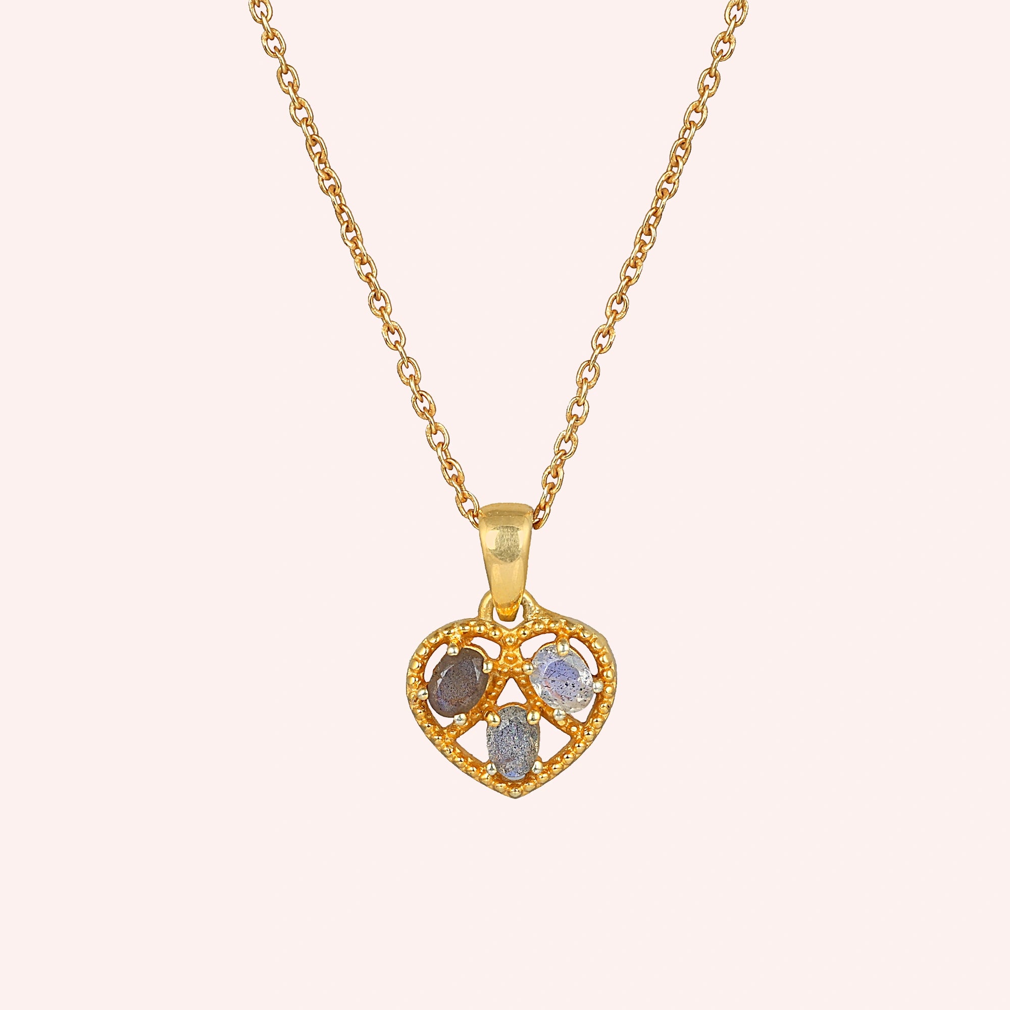 Heart_pendant_necklace_in_front_angled_view_with_gold_plated_silver_heart_and_labradorite_stones_on_solid_pink_background