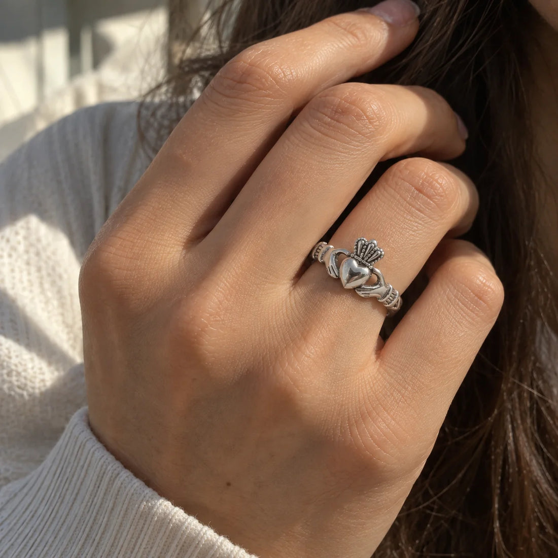 Heart_ring_in_gold_plated_silver_with_a_heart_hand_and_crown_design_at_front_angle_view_on_soft_fabric_background