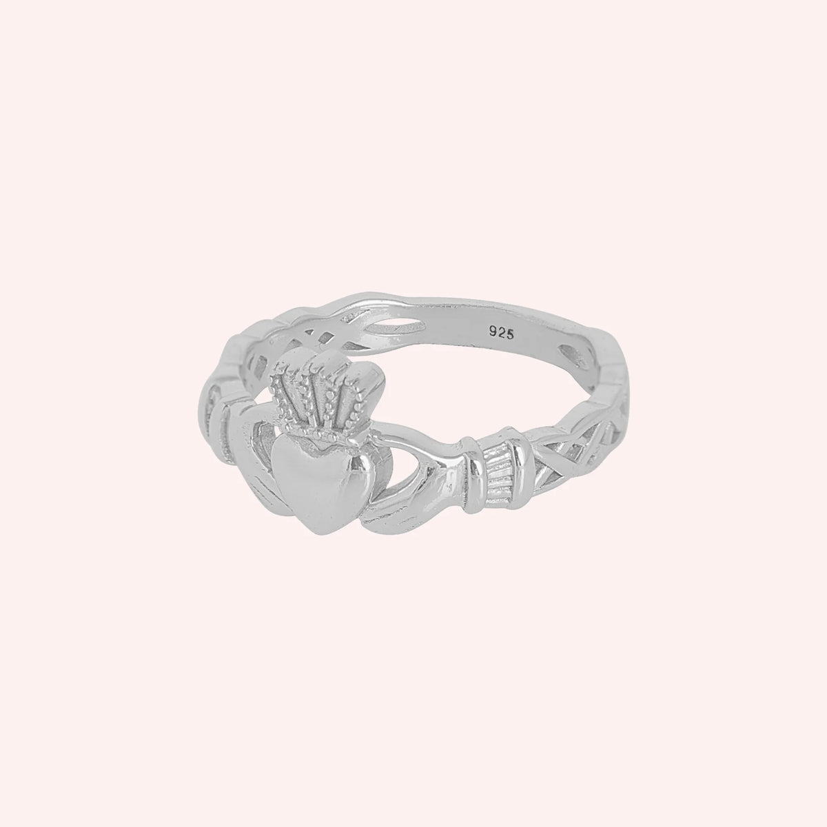 Heart_ring_in_gold_plated_silver_with_a_heart_hand_and_crown_design_at_slight_angle_view_on_solid_pink_background