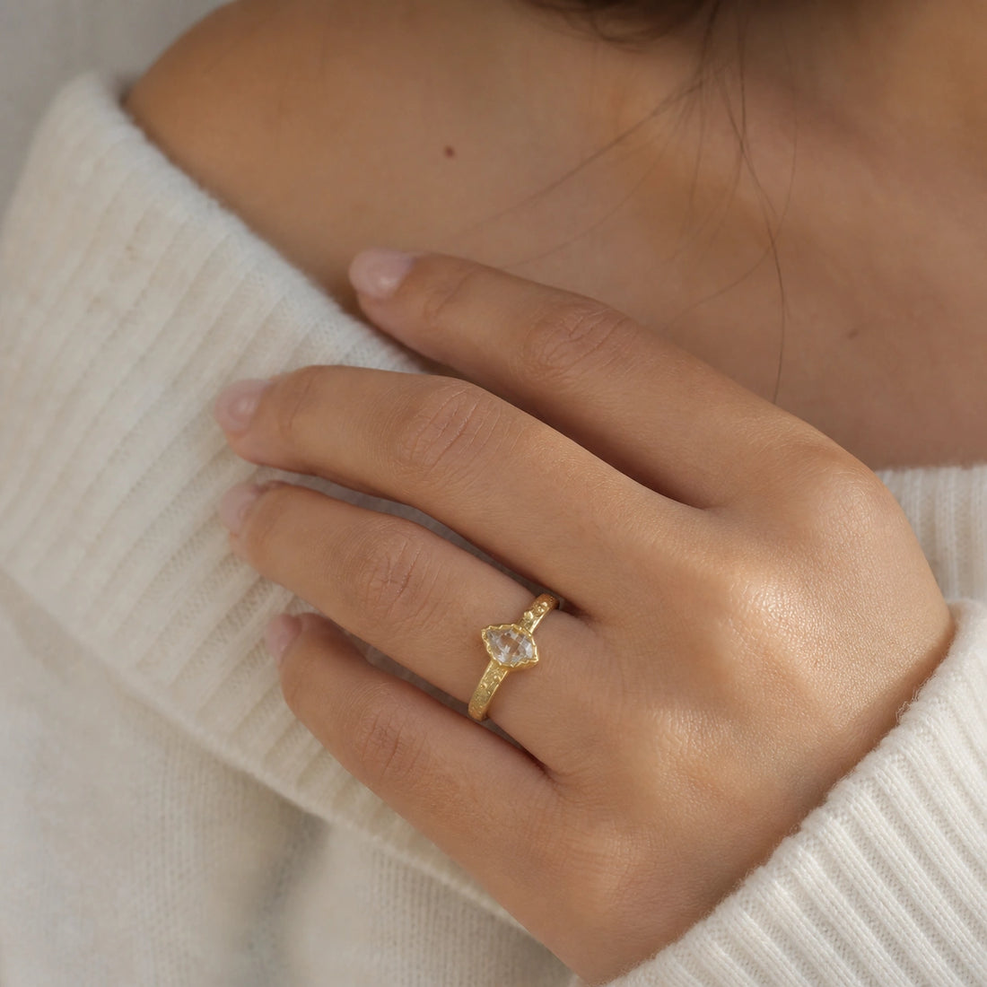 Herkimer_diamond_ring_gold_plated_silver_band_with_raw_herkimer_stone_shown_in_slightly_angled_view_on_soft_fabric_background
