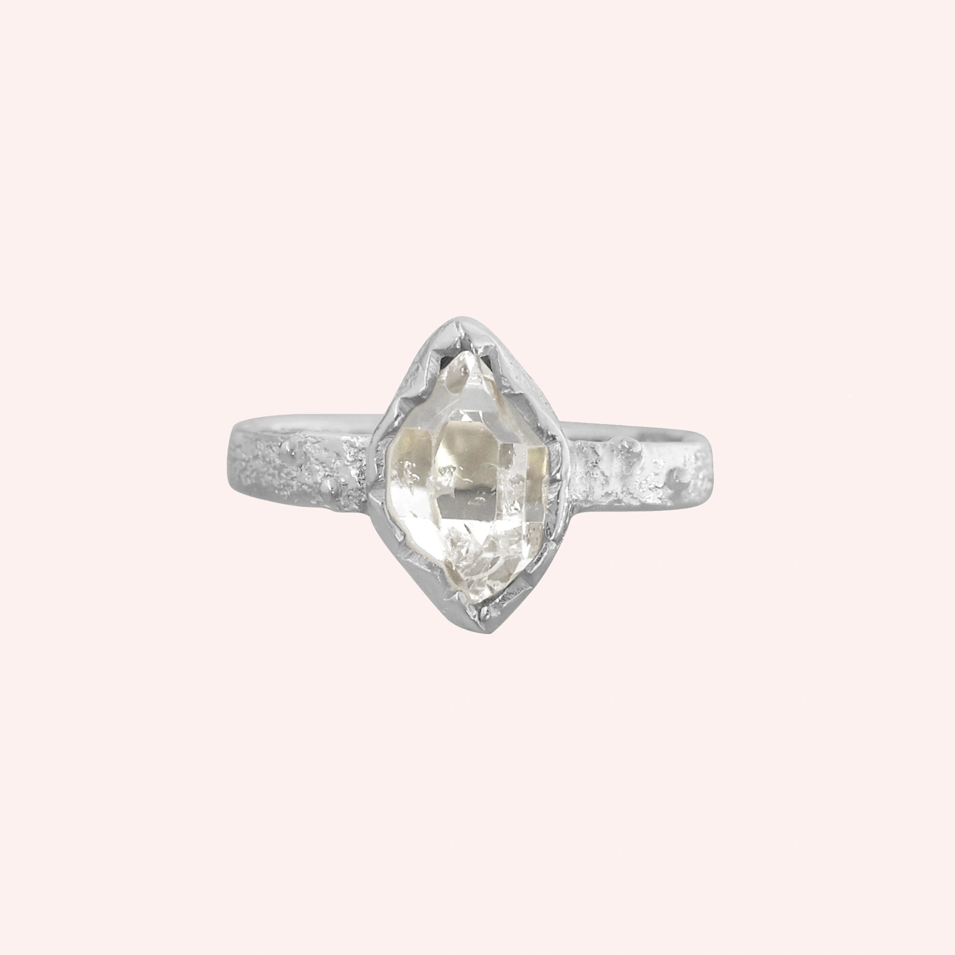 Herkimer_diamond_ring_sterling_silver_band_with_raw_herkimer_stone_shown_in_front_angle_on_solid_pink_background