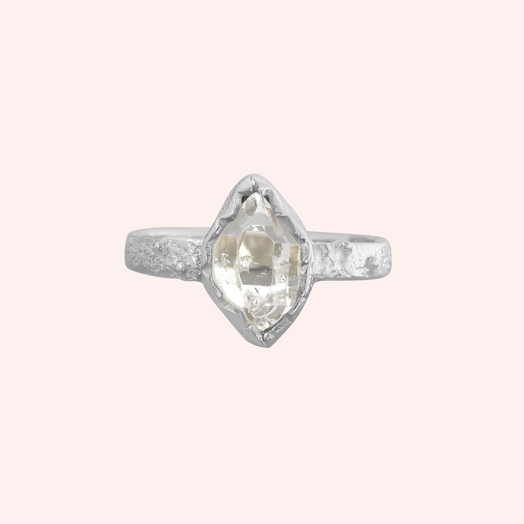 Herkimer_diamond_ring_sterling_silver_band_with_raw_herkimer_stone_shown_in_front_angle_on_solid_pink_background
