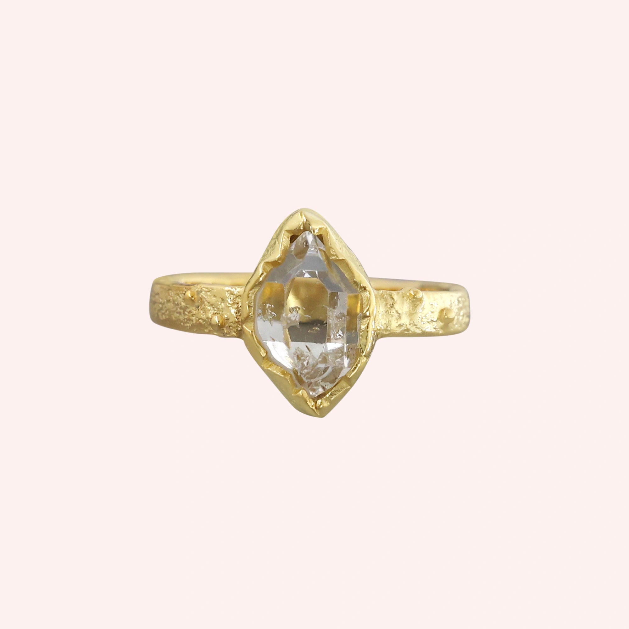 Herkimer_diamond_ring_gold_plated_silver_band_with_raw_herkimer_stone_shown_in_front_angle_on_solid_pink_background