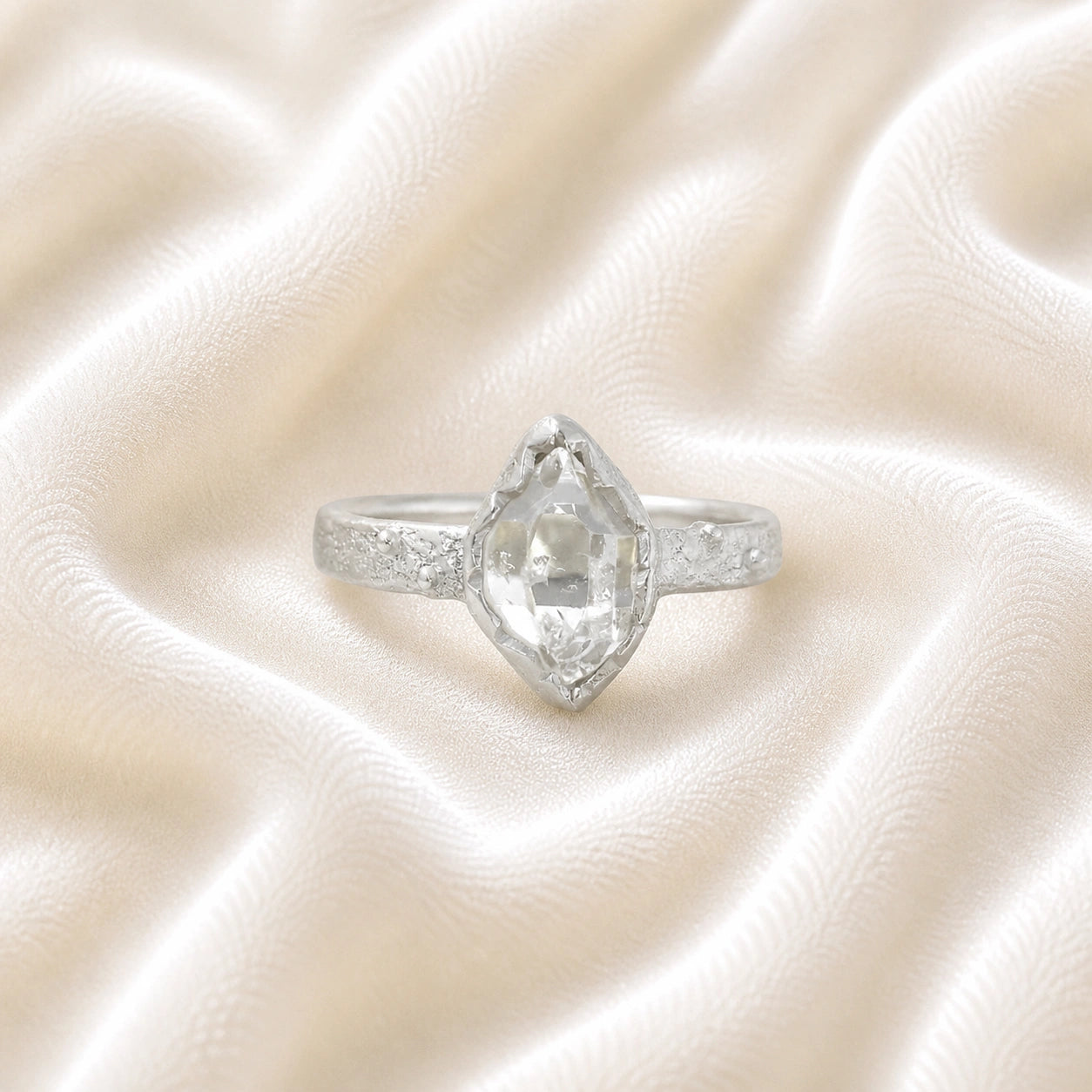 Herkimer_diamond_ring_sterling_silver_band_with_raw_herkimer_stone_shown_in_front_angle_on_soft_fabric_background