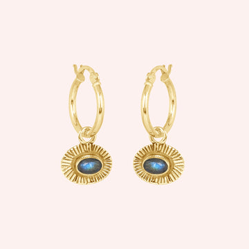 Hoop_earrings_in_gold_plated_silver_with_oval_labradorite_stone_at_front_angle_view_on_solid_pink_background