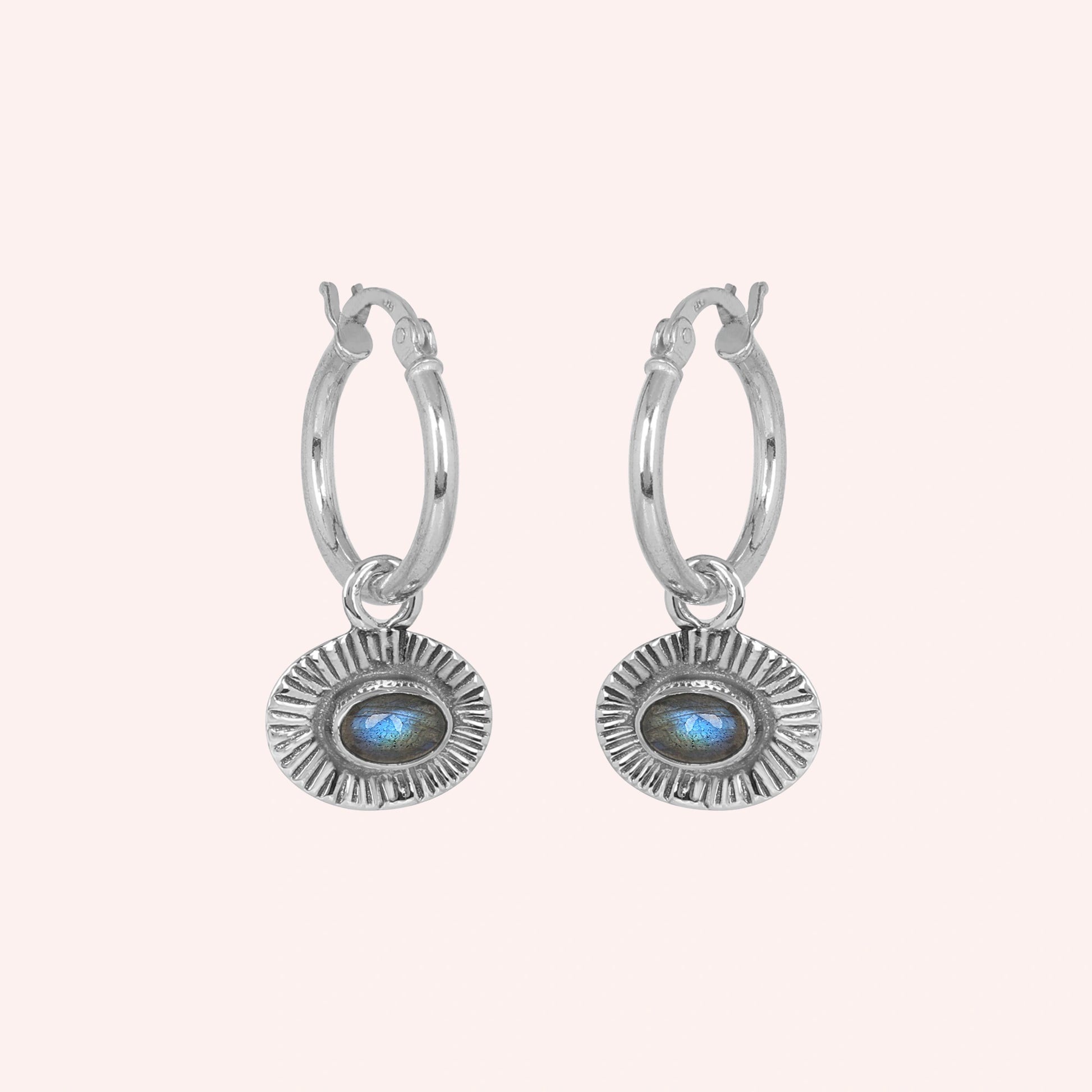 Hoop_earrings_in_sterling_silver_with_oval_labradorite_stone_at_front_angle_view_on_solid_pink_background