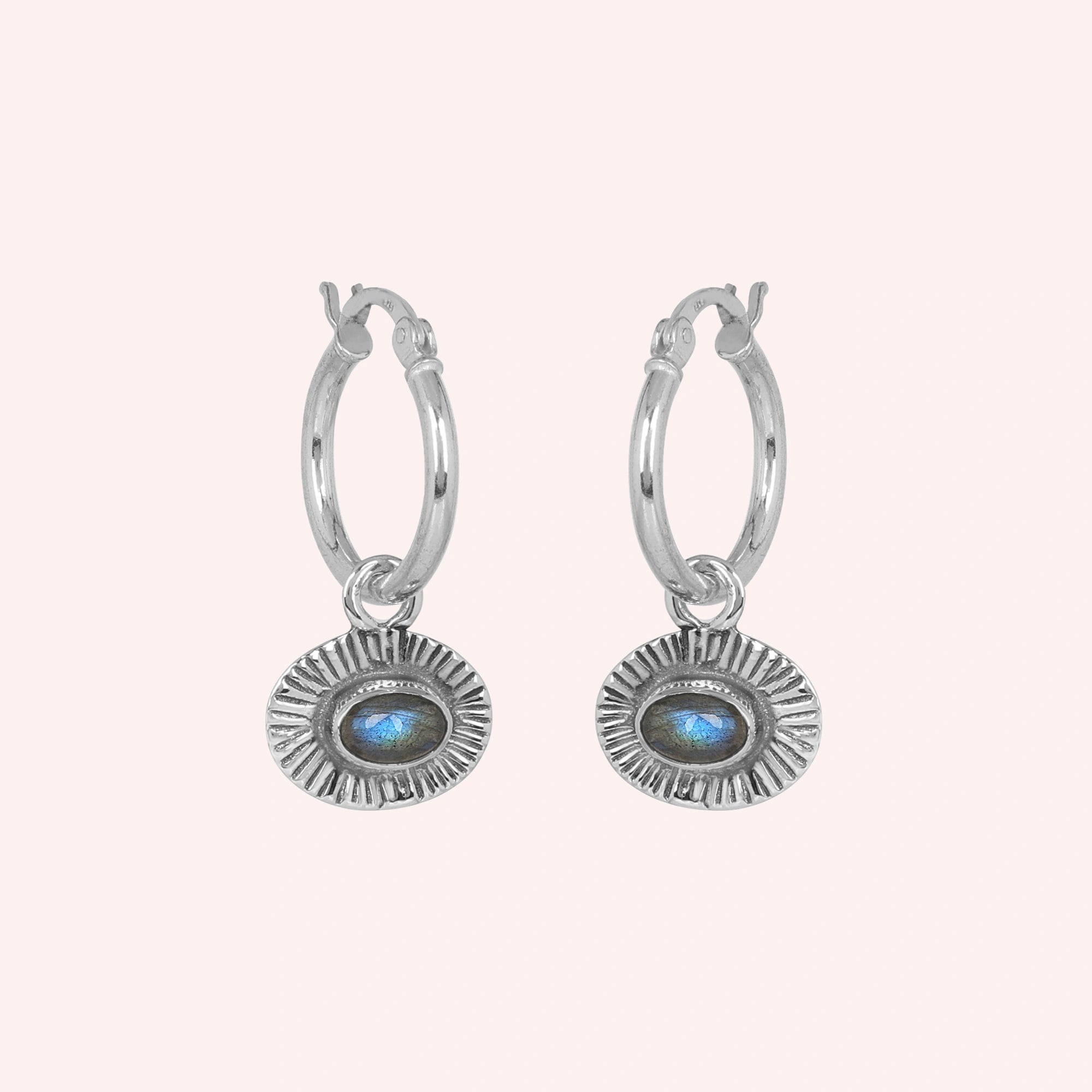 Hoop_earrings_in_sterling_silver_with_oval_labradorite_stone_at_front_angle_view_on_solid_pink_background