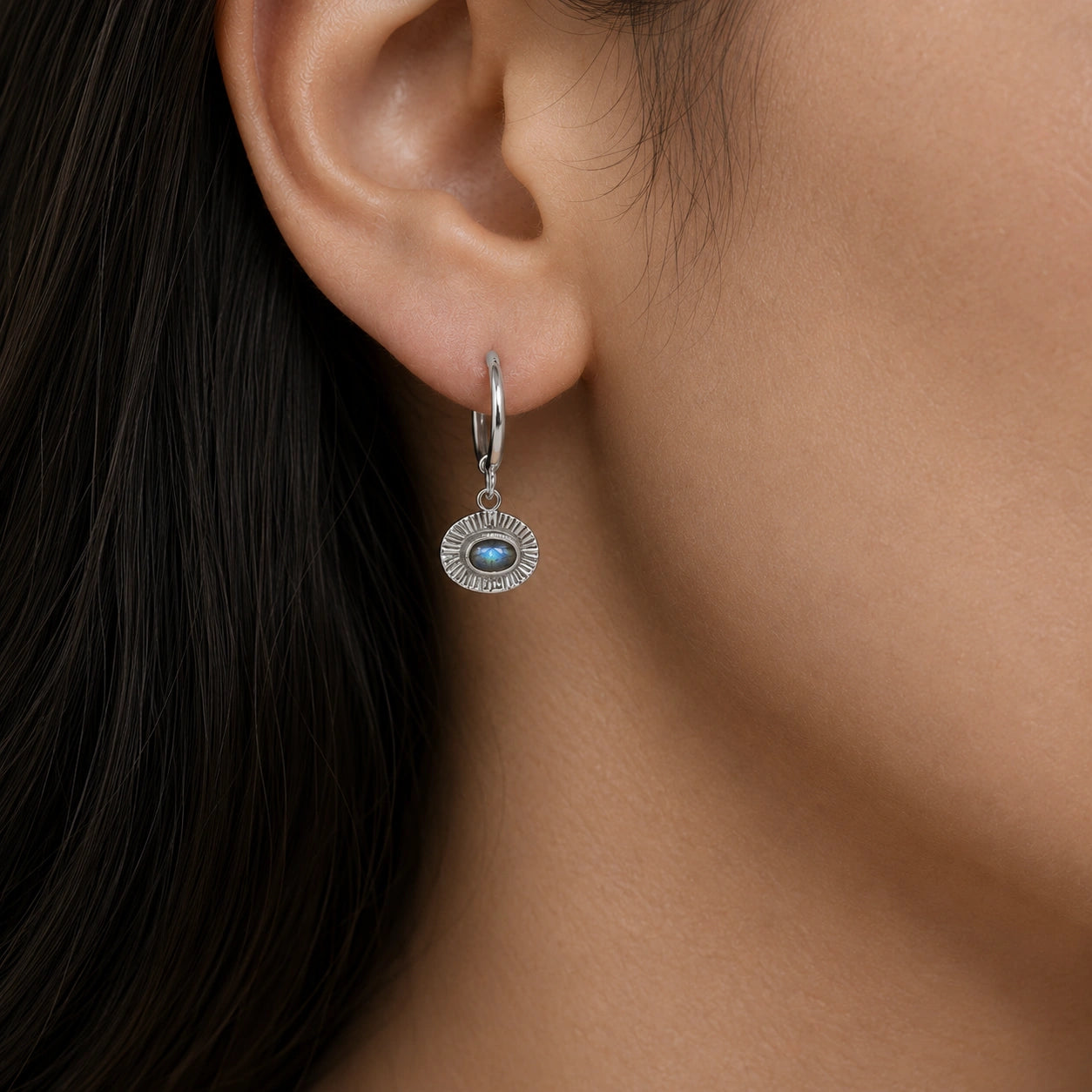 Hoop_earrings_in_sterling_silver_with_oval_labradorite_stone_worn_by_a_model