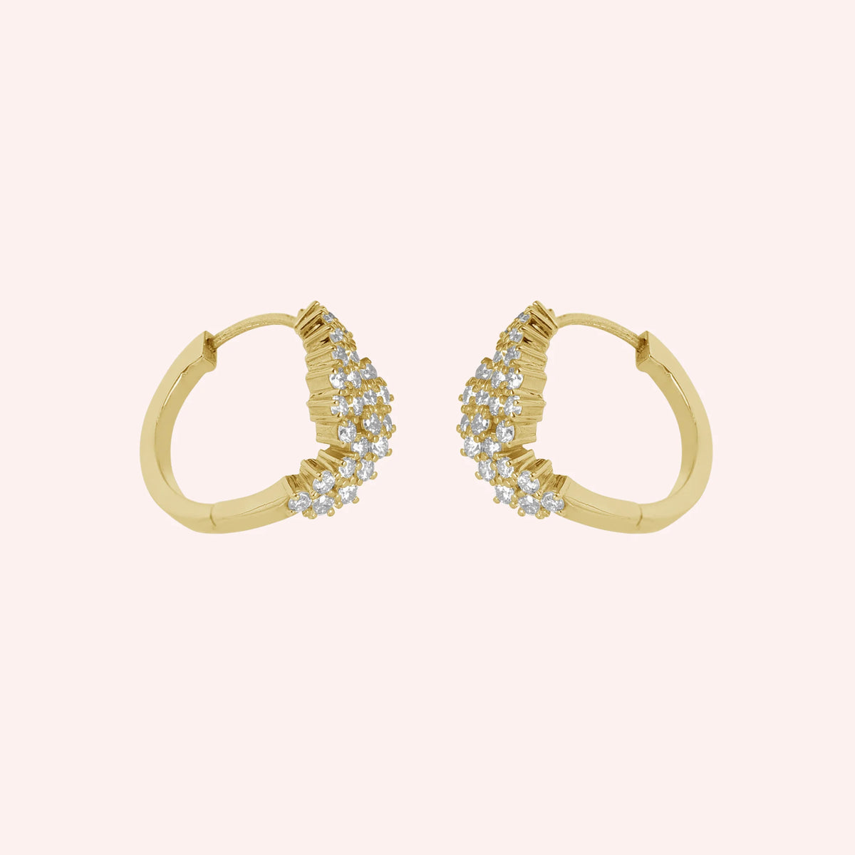 Huggie_earrings_in_gold_plated_silver_with_lab_grown_diamonds_at_side_angle_view_on_solid_pink_background
