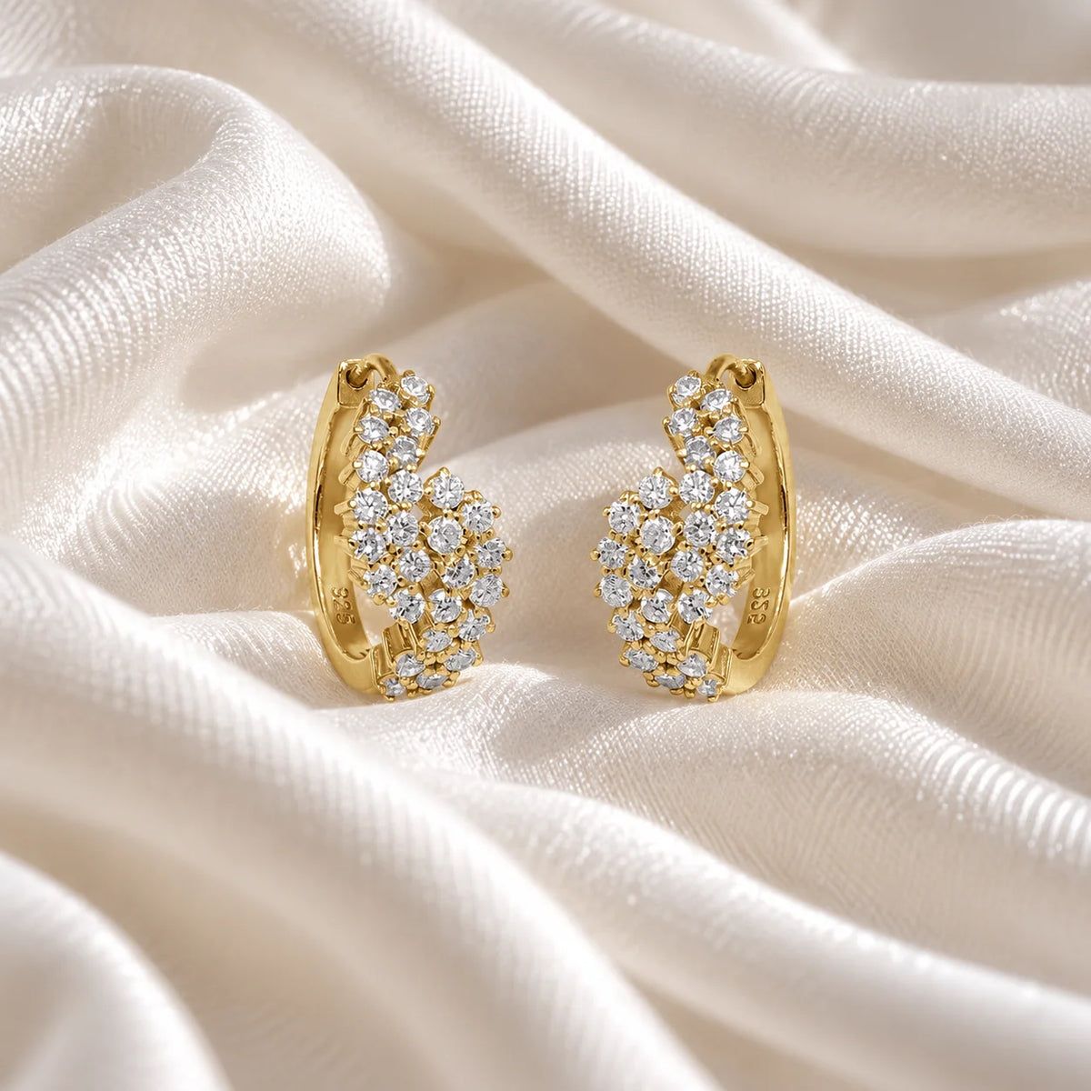 Huggie_earrings_in_gold_plated_silver_with_lab_grown_diamonds_at_front_angle_view_on_soft_fabric_background
