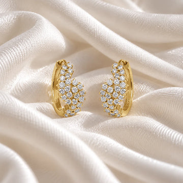 Huggie_earrings_in_gold_plated_silver_with_lab_grown_diamonds_at_front_angle_view_on_soft_fabric_background
