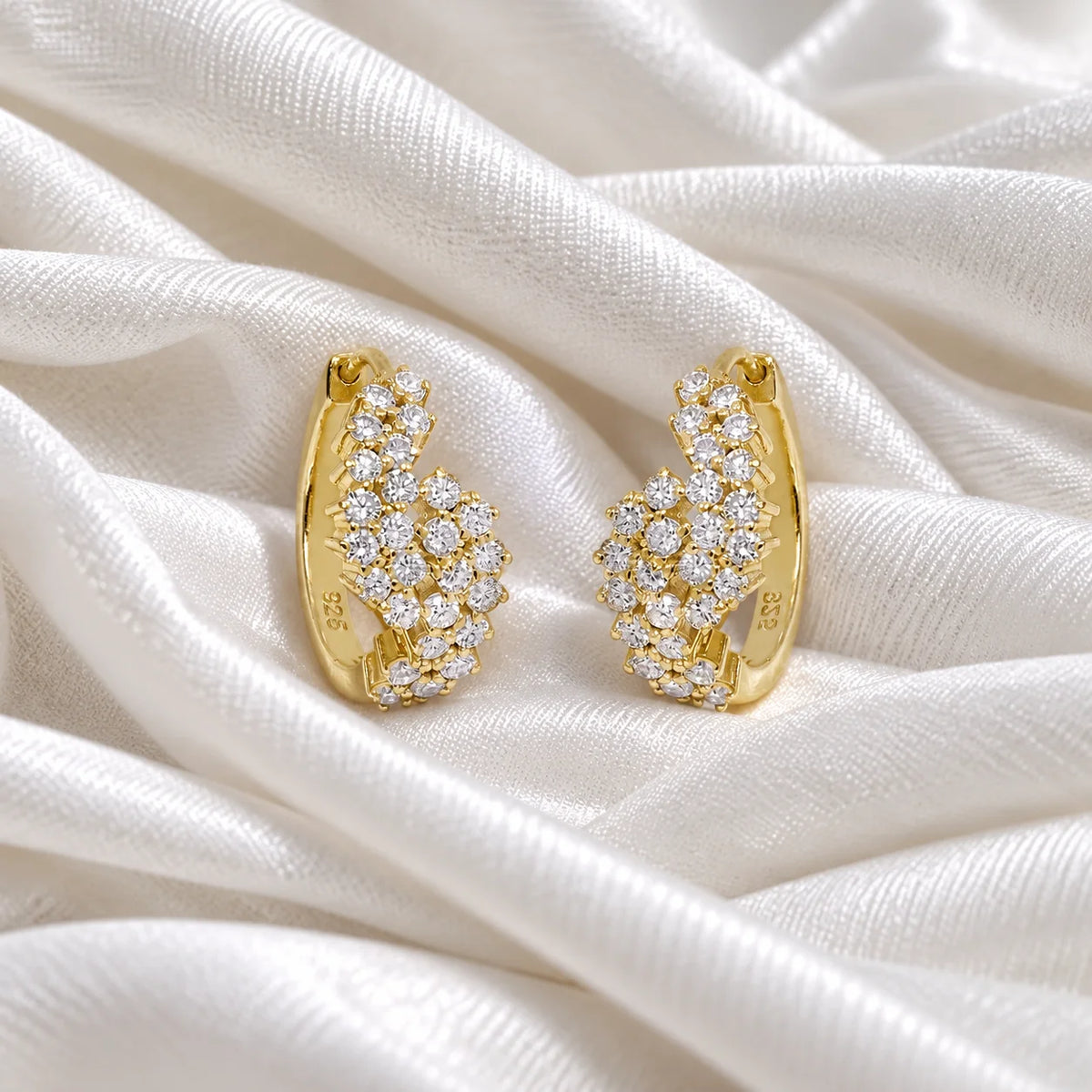 Huggie_earrings_in_gold_plated_silver_with_lab_grown_diamonds_at_front_angle_view_on_soft_fabric_background