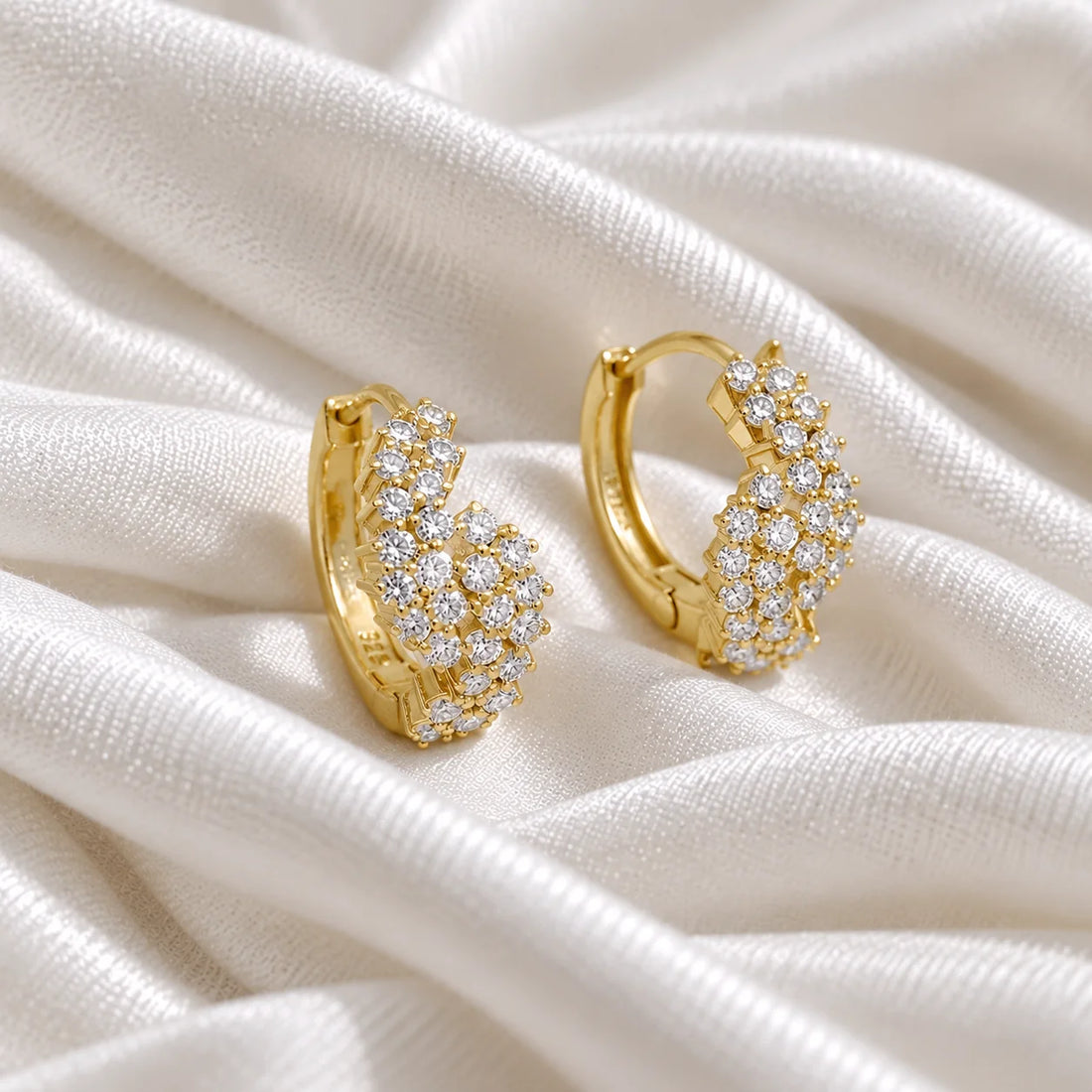 Huggie_earrings_in_gold_plated_silver_with_lab_grown_diamonds_at_side_angle_view_on_soft_fabric_background