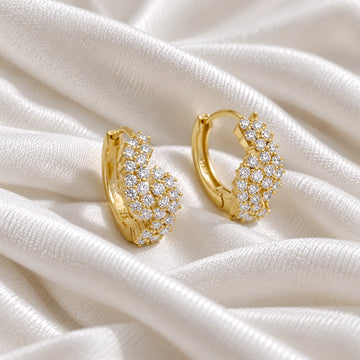 Huggie_earrings_in_gold_plated_silver_with_lab_grown_diamonds_at_side_angle_view_on_soft_fabric_background
