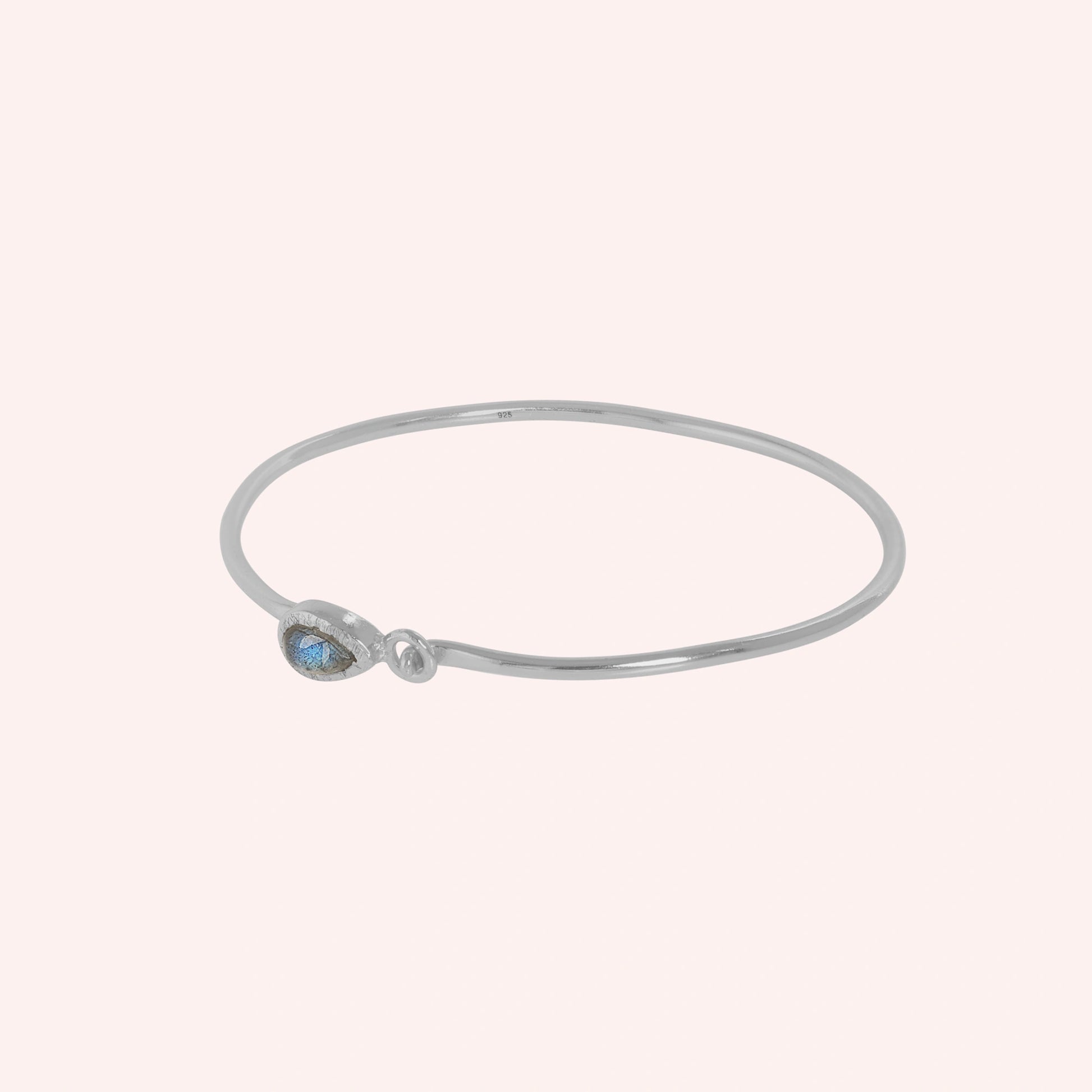 Labradorite_bracelet_in_sterling_silver_with_an_teardrop_labradorite_stone_at_slight_angle_view_on_solid_pink_background