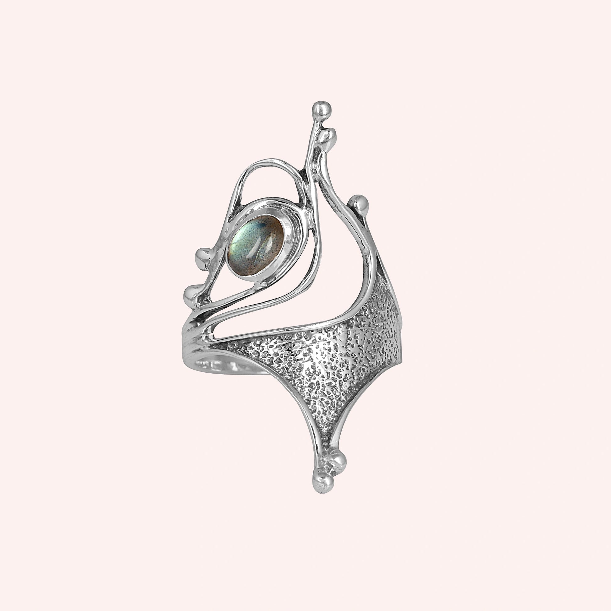 Sterling silver labradorite ring abstract sculptural design with textured metal viewed straight angled on light pink background