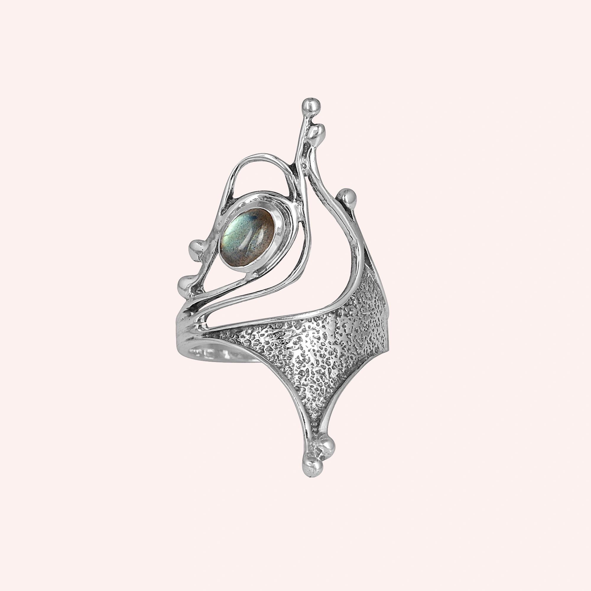 Sterling silver labradorite ring abstract sculptural design with textured metal viewed straight angled on light pink background