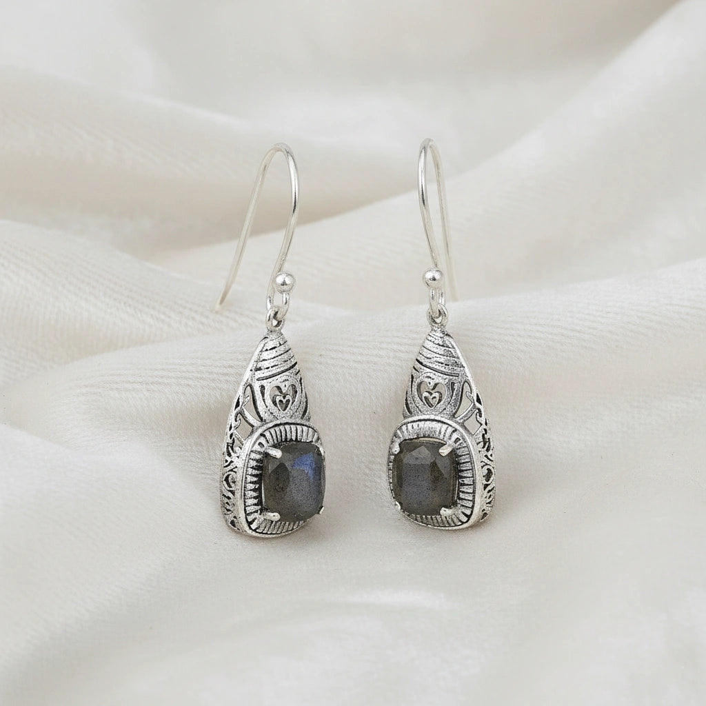 Gemstone earrings silver charm studs with vibrant labradorite stones viewed slightly angled on soft off white fabric