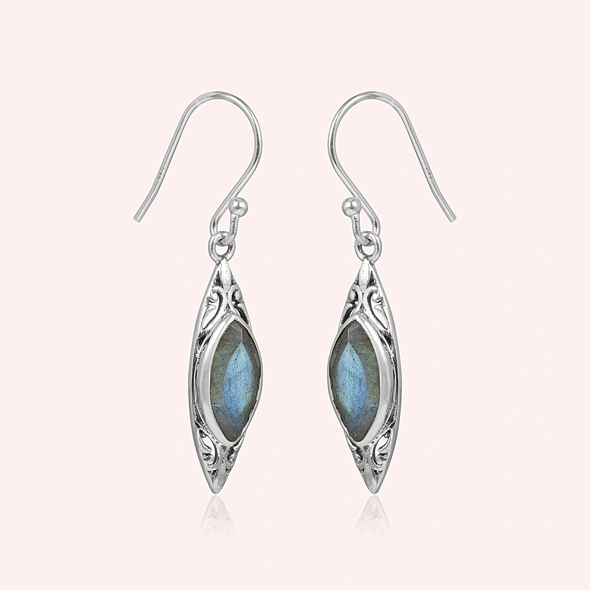 Marquise earrings silver dangle design with carved border and central labradorite viewed straight on light pink background