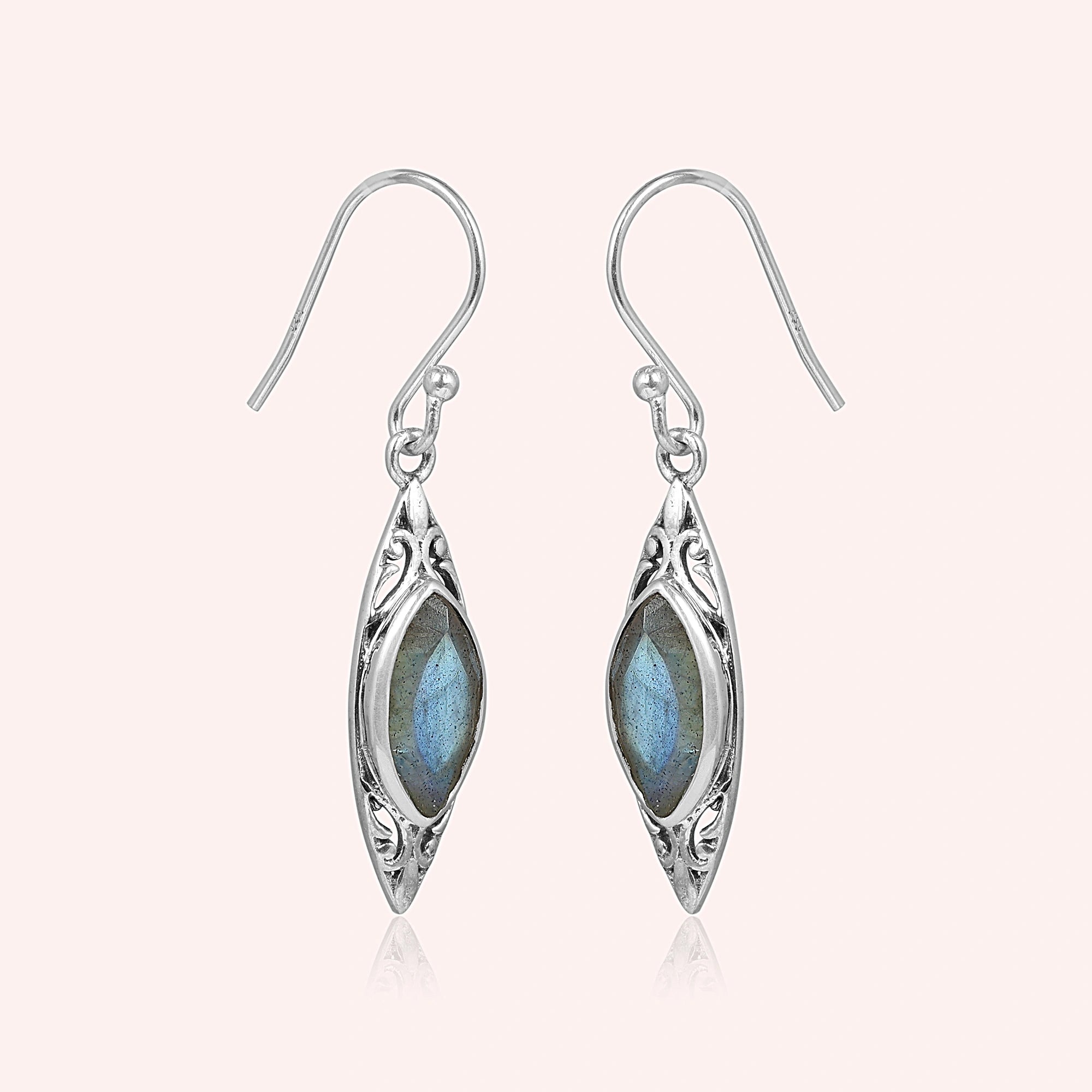 Marquise earrings silver dangle design with carved border and central labradorite viewed straight on light pink background