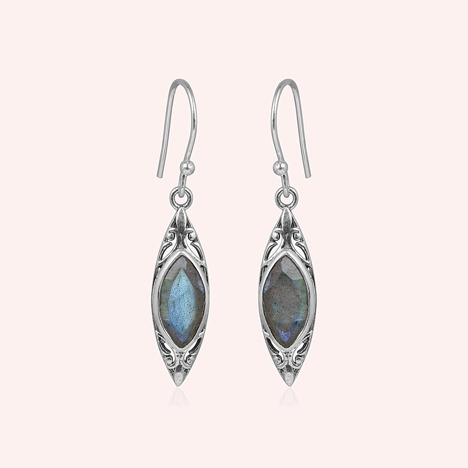 Marquise earrings silver dangle design with decorative border and central labradorite viewed straight on light pink background