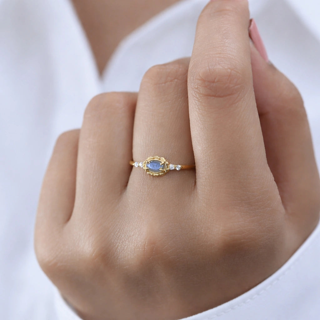 Labradorite-ring-with-white-topaz-stones-gold-plated-silver-angled-view-on-white-satin-background